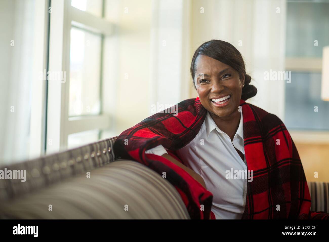 Mature woman sitting on her sofa at home Stock Photo - Alamy