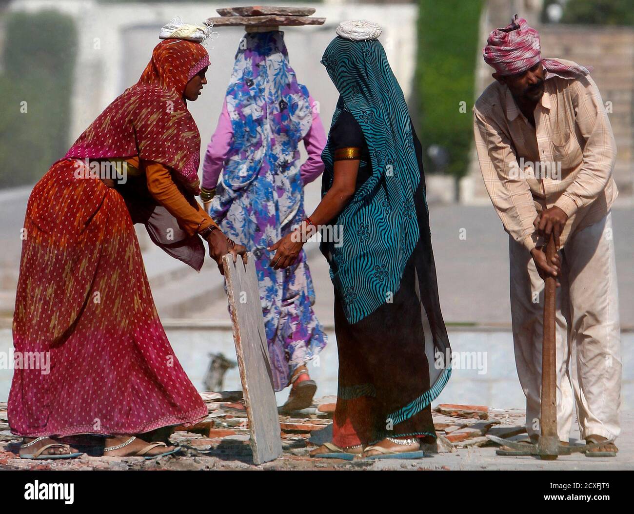 A family of labourers remove flooring during renovation work at the Yadavindra gardens in the town of Pinjore, 20km (12 miles) from the northern Indian city of Chandigarh September 30, 2010.  REUTERS/Andrew Caballero-Reynolds (INDIA - Tags: SOCIETY) Stock Photo