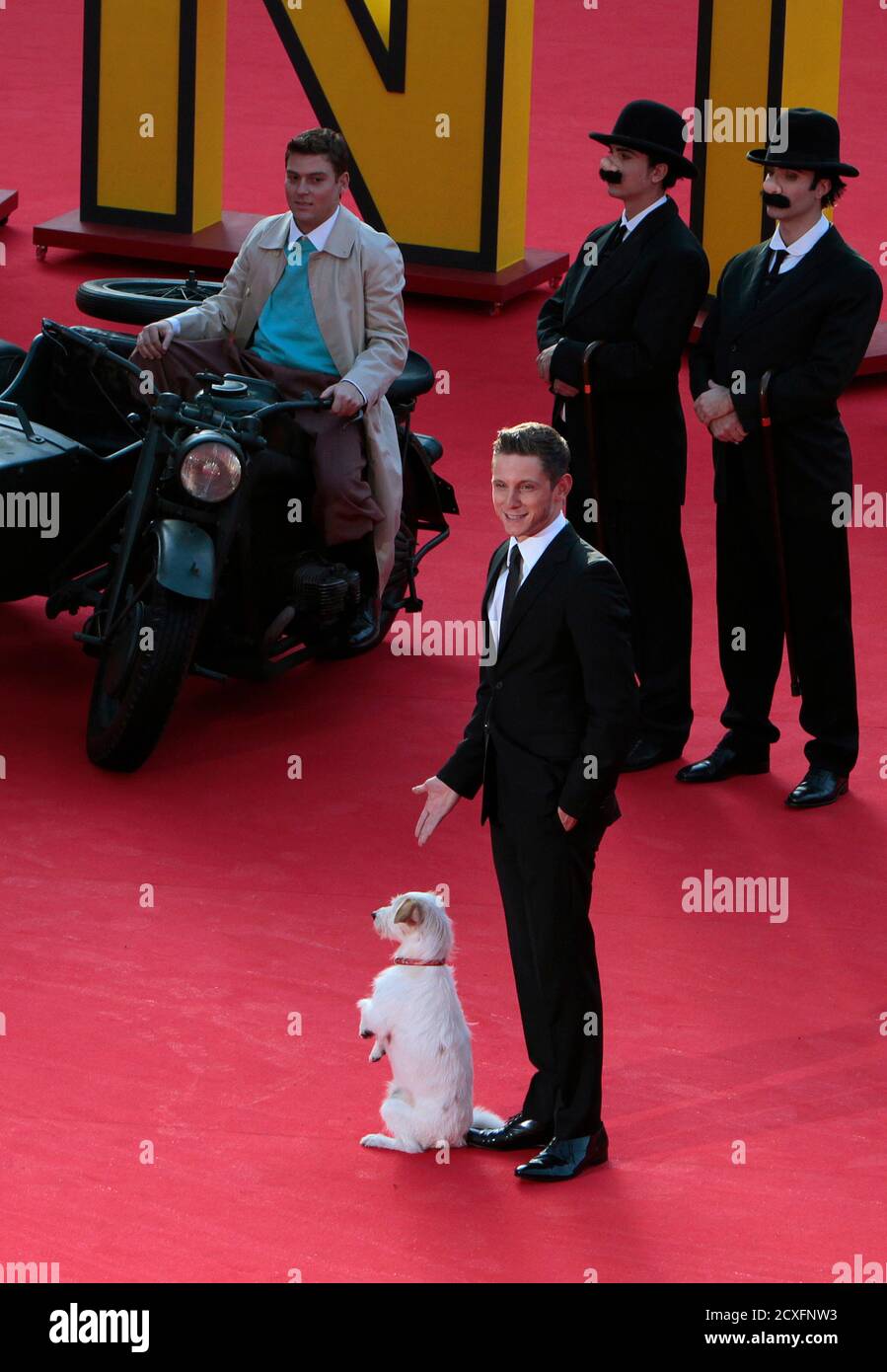 Actor Jamie Bell (C, bottom) gestures as he poses with 'Milu' the dog in front of other performers during a photocall of the movie 'Tintin' at the Rome Film Festival October 28, 2011. REUTERS/Alessandro Bianchi (ITALY - Tags: ENTERTAINMENT) Stock Photo