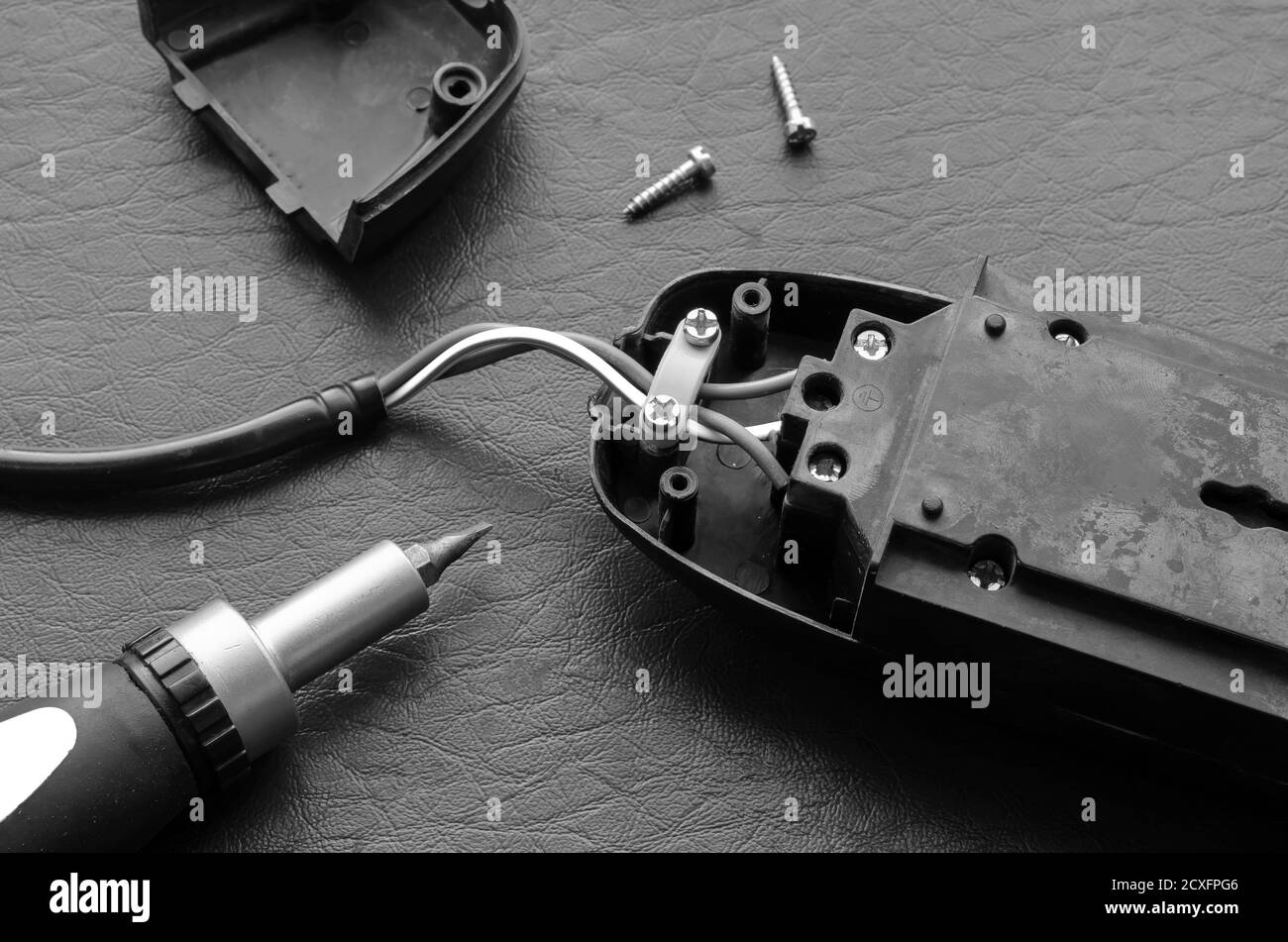 Screwdriver and power strip on a black textured surface. Electrical