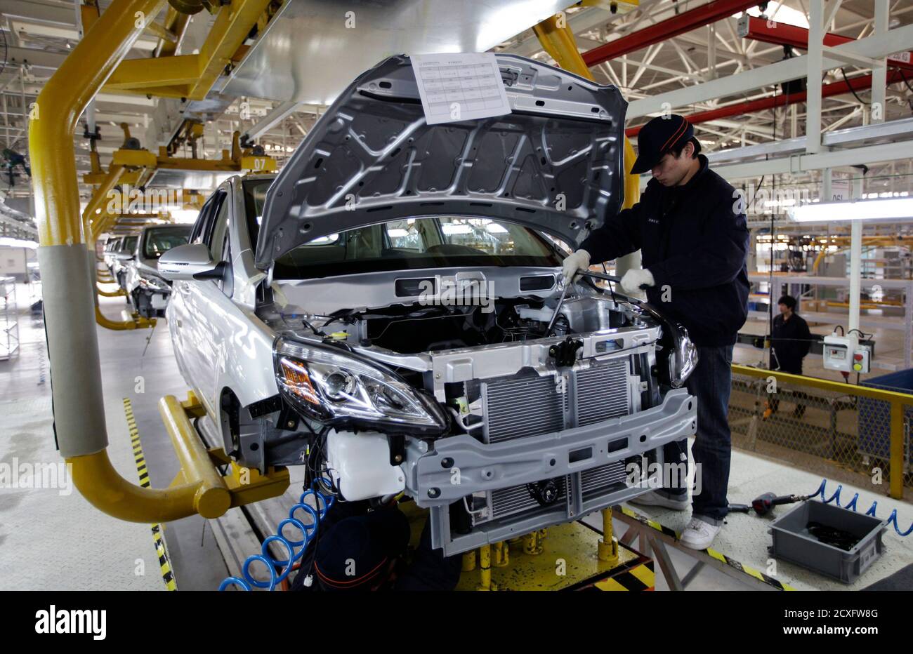 An employee works on the Beiqi E150EV car assembly line of Beijing Electric Vehicle Company, in Beijing November 7, 2012. China's central government will allocate funding to support technological innovation projects such as electric vehicles, plug-in hybrid vehicles and fuel cell vehicles in the nation's new energy auto industry, according to an announcement from the Ministry of Finance. A statement on the ministry's website also said that funds will be used to support the development of new vehicle batteries. REUTERS/Jason Lee (CHINA - Tags: TRANSPORT BUSINESS ENERGY SCIENCE TECHNOLOGY) Stock Photo