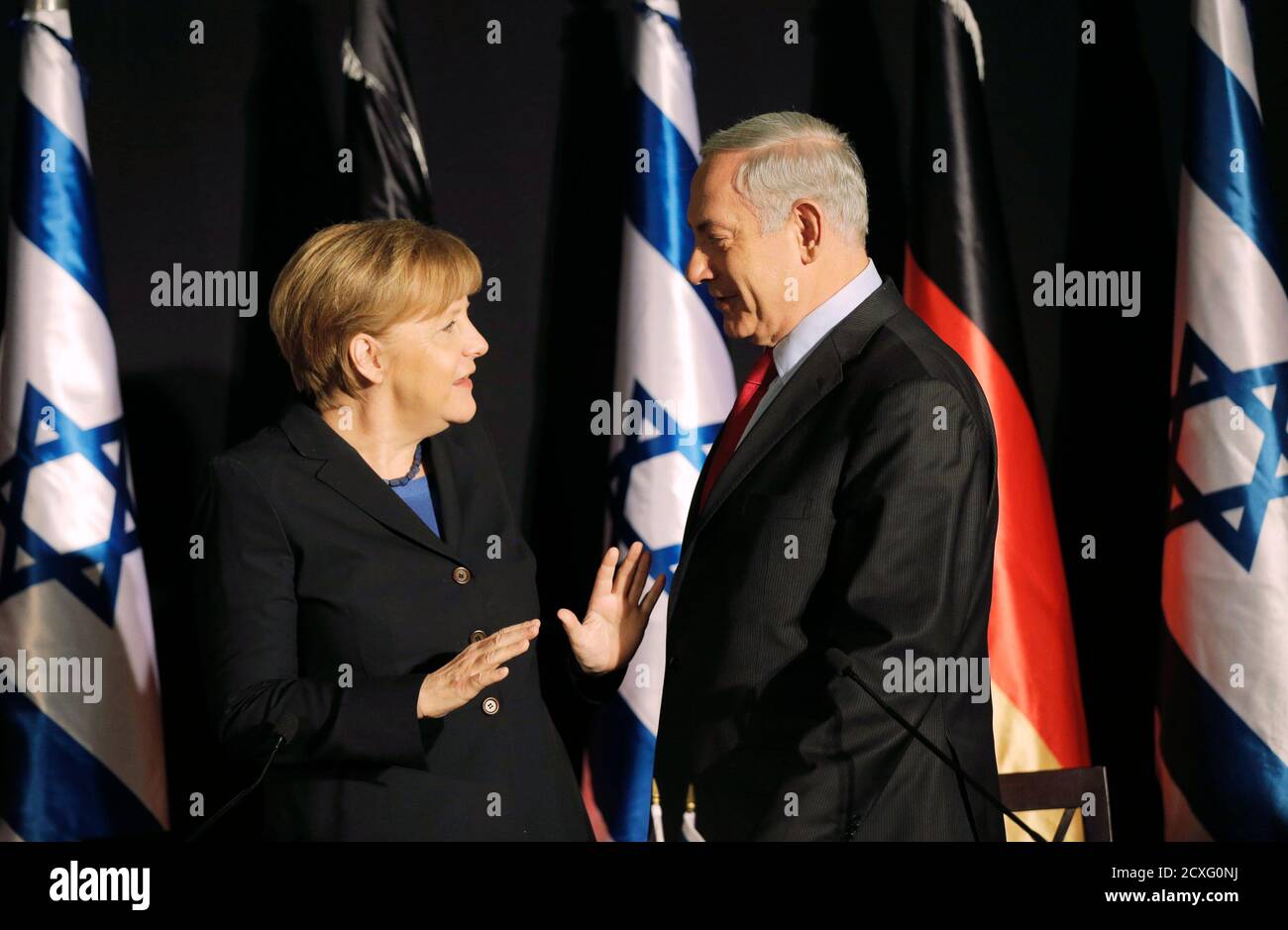 Israel's Prime Minister Benjamin Netanyahu (R) stands next to German Chancellor Angela Merkel after their joint news conference in Jerusalem February 25, 2014. Germany views Iran as a potential threat not just to Israel, but also to European countries, Chancellor Angela Merkel said on Tuesday. REUTERS/Ammar Awad    (JERUSALEM - Tags: POLITICS) Stock Photo