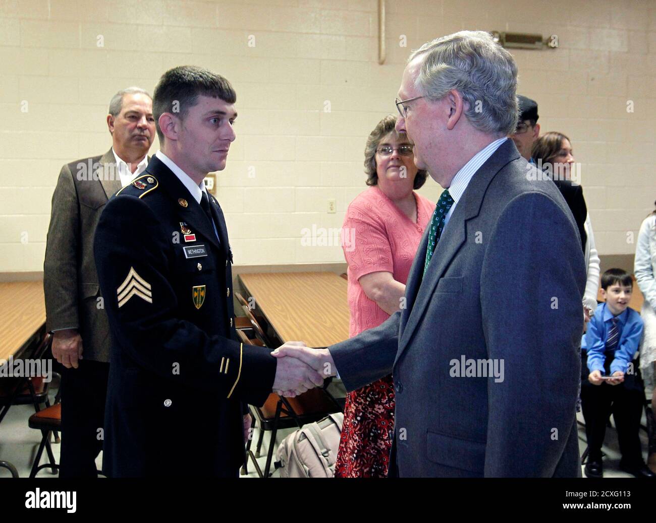 Sen. Mitch McConnell (R-KY) shakes hands with Kentucky National Guard Sgt. Jesse Wethington of 623 Field Artillery before presenting him with a Purple Heart at the VFW Post 1170 in Louisville, Kentucky, April 5, 2014.       REUTERS/John Sommers II     (UNITED STATES - Tags: POLITICS MILITARY) Stock Photo