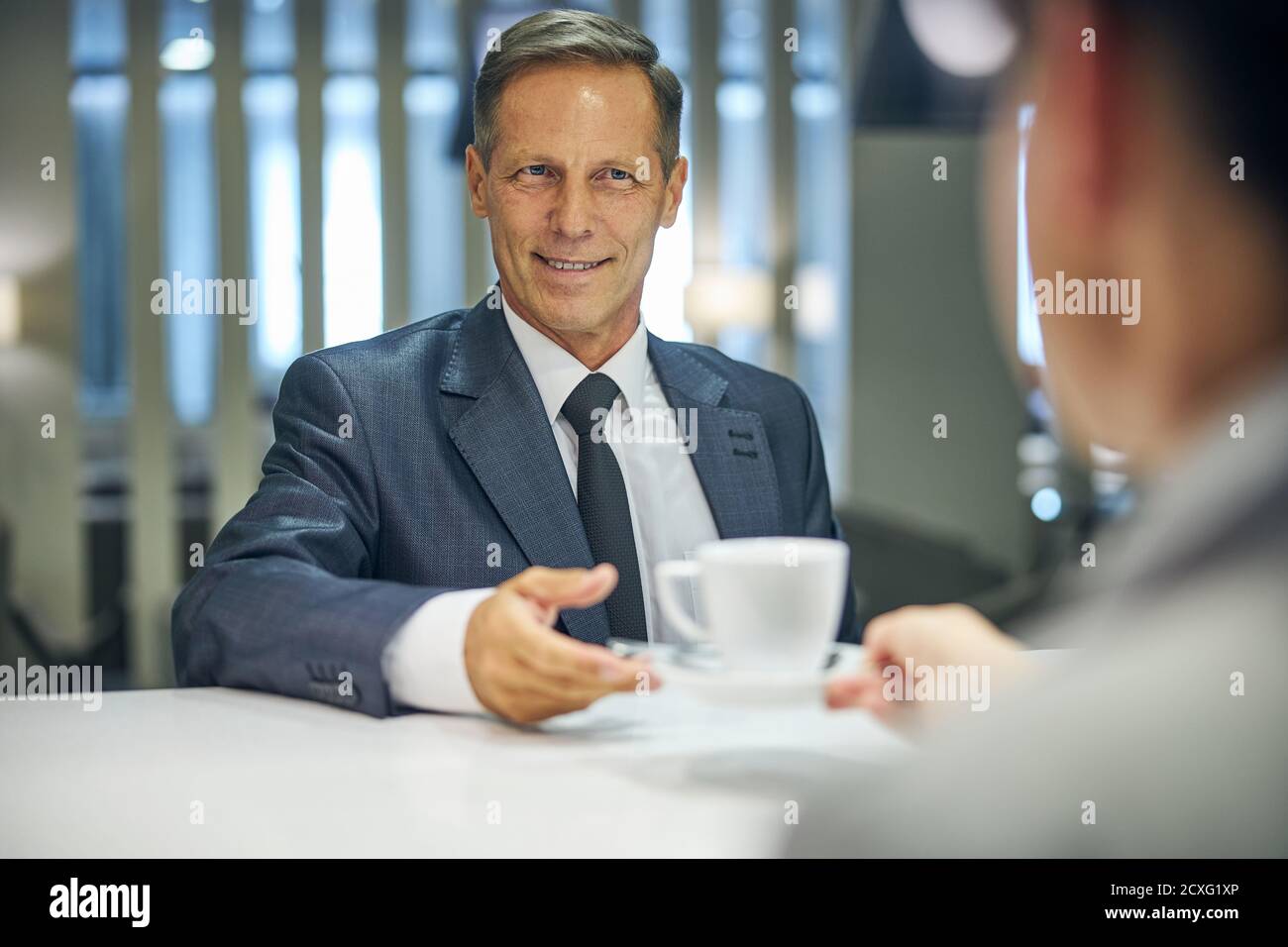Smiling businessman having hot drink at bar Stock Photo
