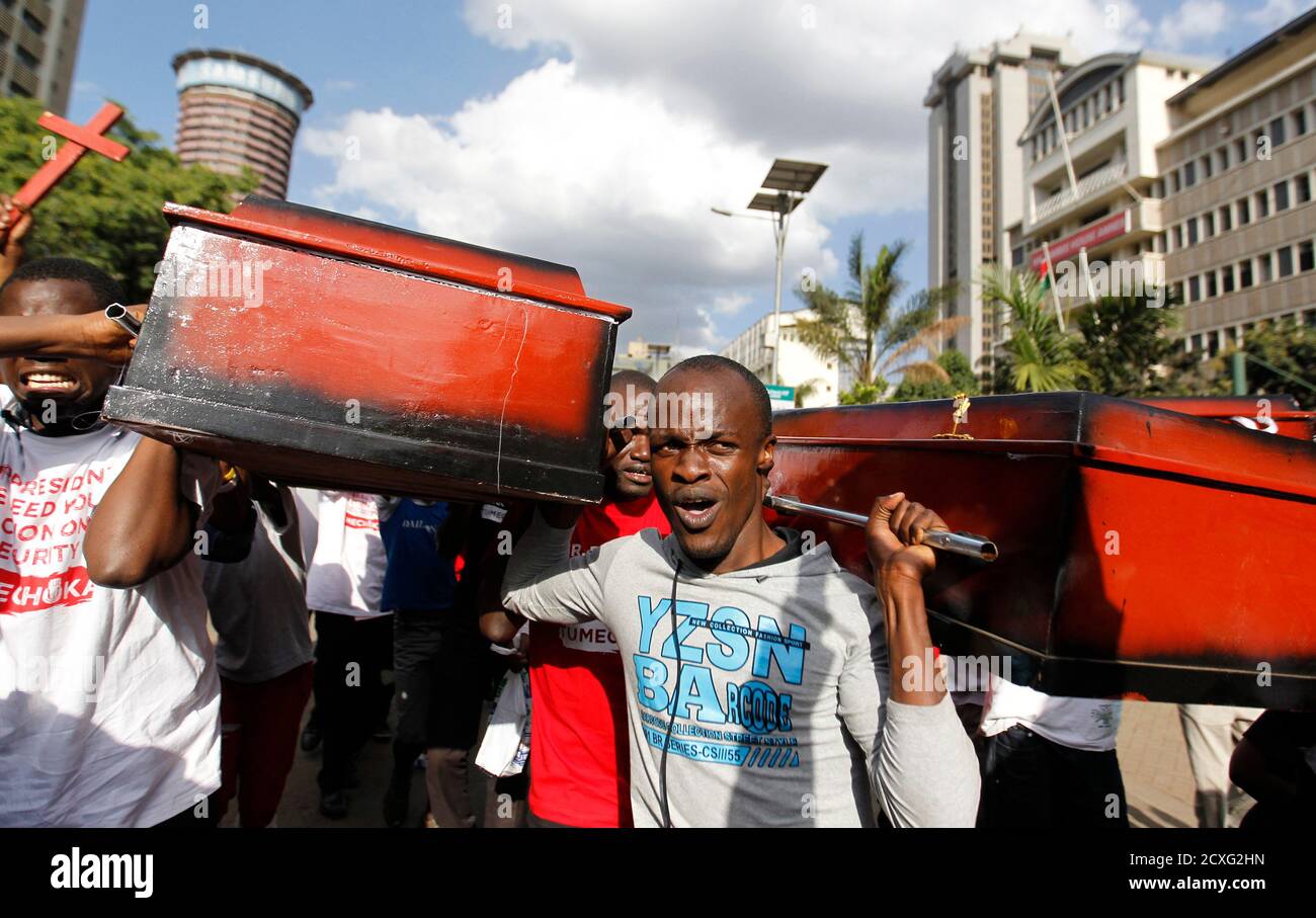 Protesters carry coffins during the #OccupyHarambeeAve protest in Kenya's capital Nairobi November 25, 2014. Kenyan police used teargas to disperse demonstrators shouting 'President, Stop the killings!' outside President Uhuru Kenyatta's offices on Tuesday, in the protest over 28 people killed in a weekend attack claimed by Islamist militants. REUTERS/Thomas Mukoya (KENYA - Tags: CIVIL UNREST POLITICS) Stock Photo