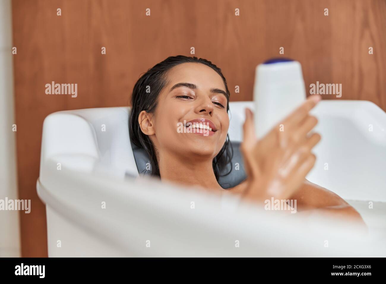 Beautiful young woman holding shower gel while taking bath Stock Photo Alamy