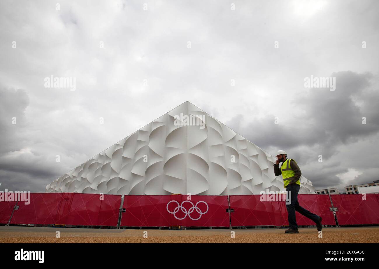 A worker walks past the Olympic basketball arena in Olympic Park, Stratford, east London, July 19, 2012. The 2012 London Olympic Games will begin in just over a week.  REUTERS/Andrew Winning (BRITAIN - Tags: SPORT OLYMPICS BASKETBALL) Stock Photo
