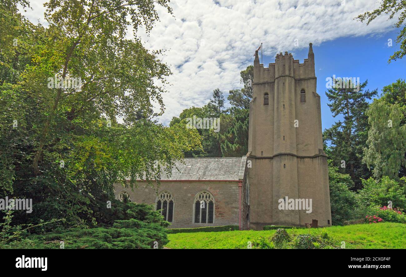 Buckfast Abbey against a blue cloudy sky surrounded by lush green foliage in Dartmoor National Park Stock Photo