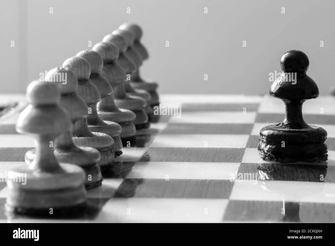 One pawn is positioned against a row of enemy pawns. Stock Photo