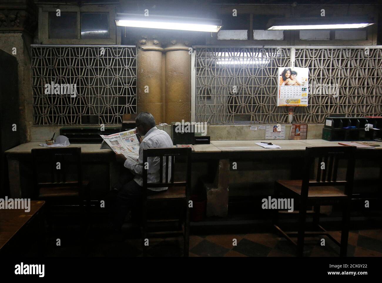 An employee reads a newspaper inside the delivery section room of the
