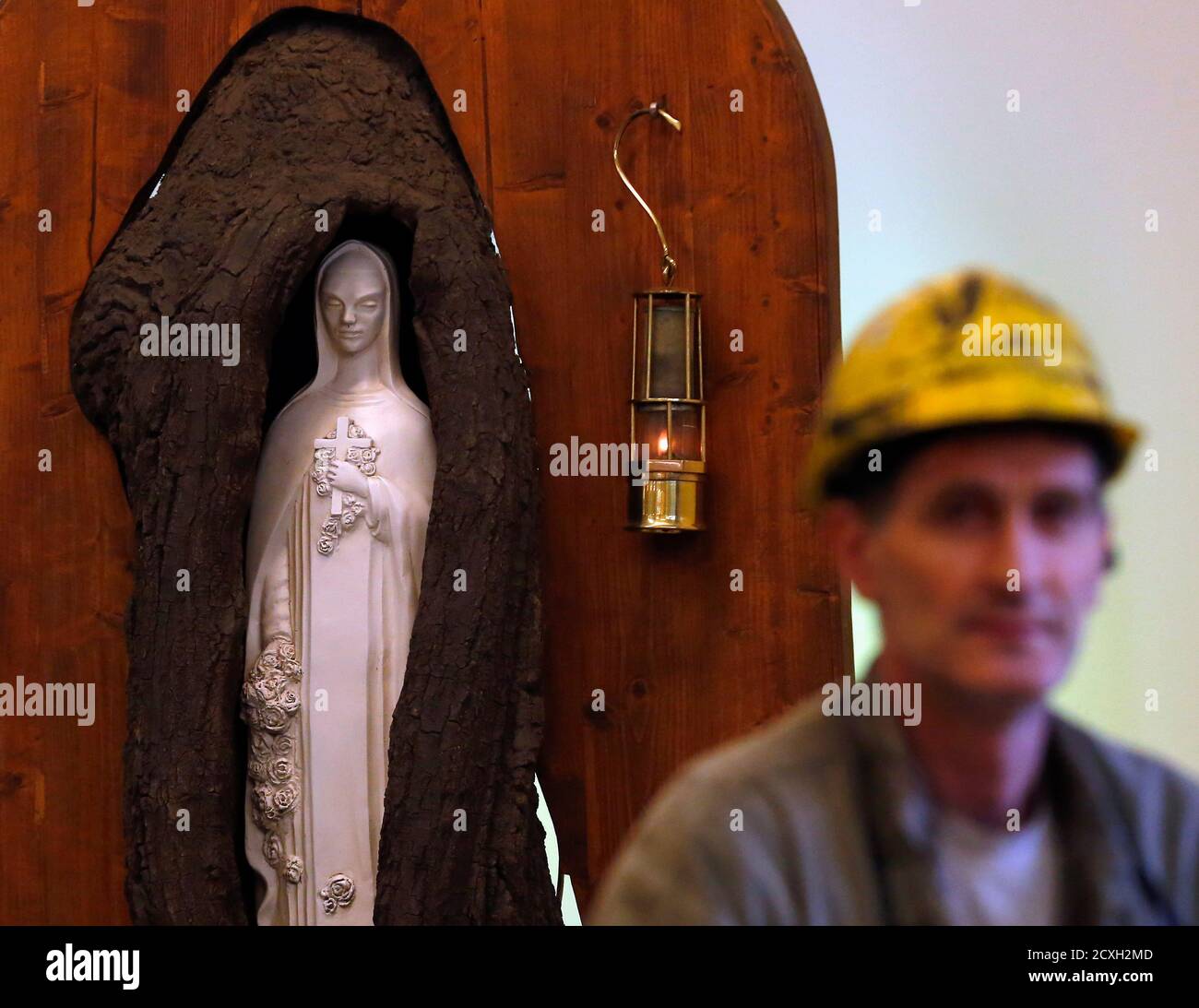 A miner sits front of the statue of St. Barbara, saint of the miners,  during last working day at Hungary's last hard coal deep-cast mine at  Markushegy December 23, 2014.The underground mine,