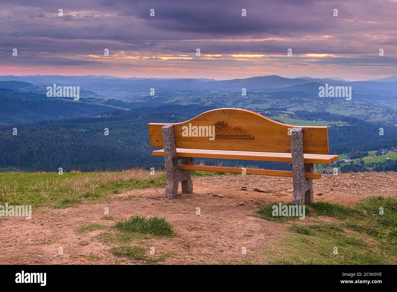 a bench on the Ochodzita sightseeing viewpoint with a cloudy sunset sky Stock Photo