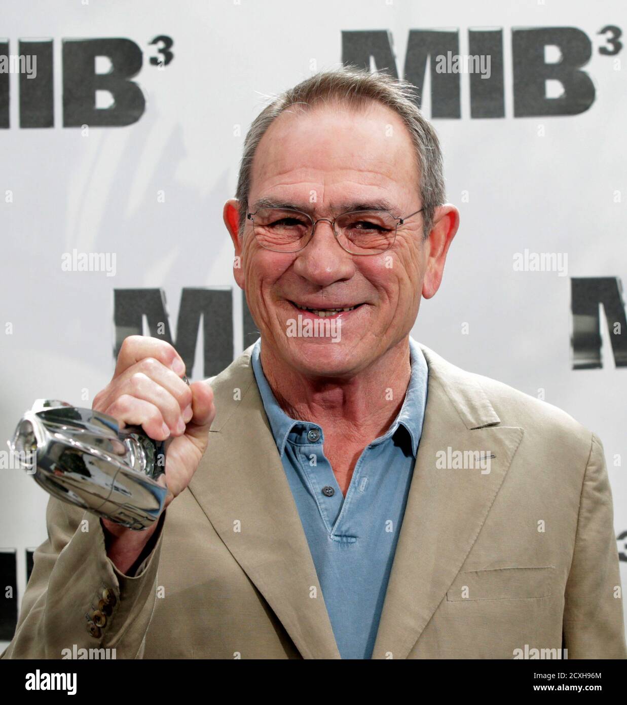 Cast member Tommy Lee Jones holds a prop gun to be placed in a time capsule  at a photo call while promoting his upcoming film 