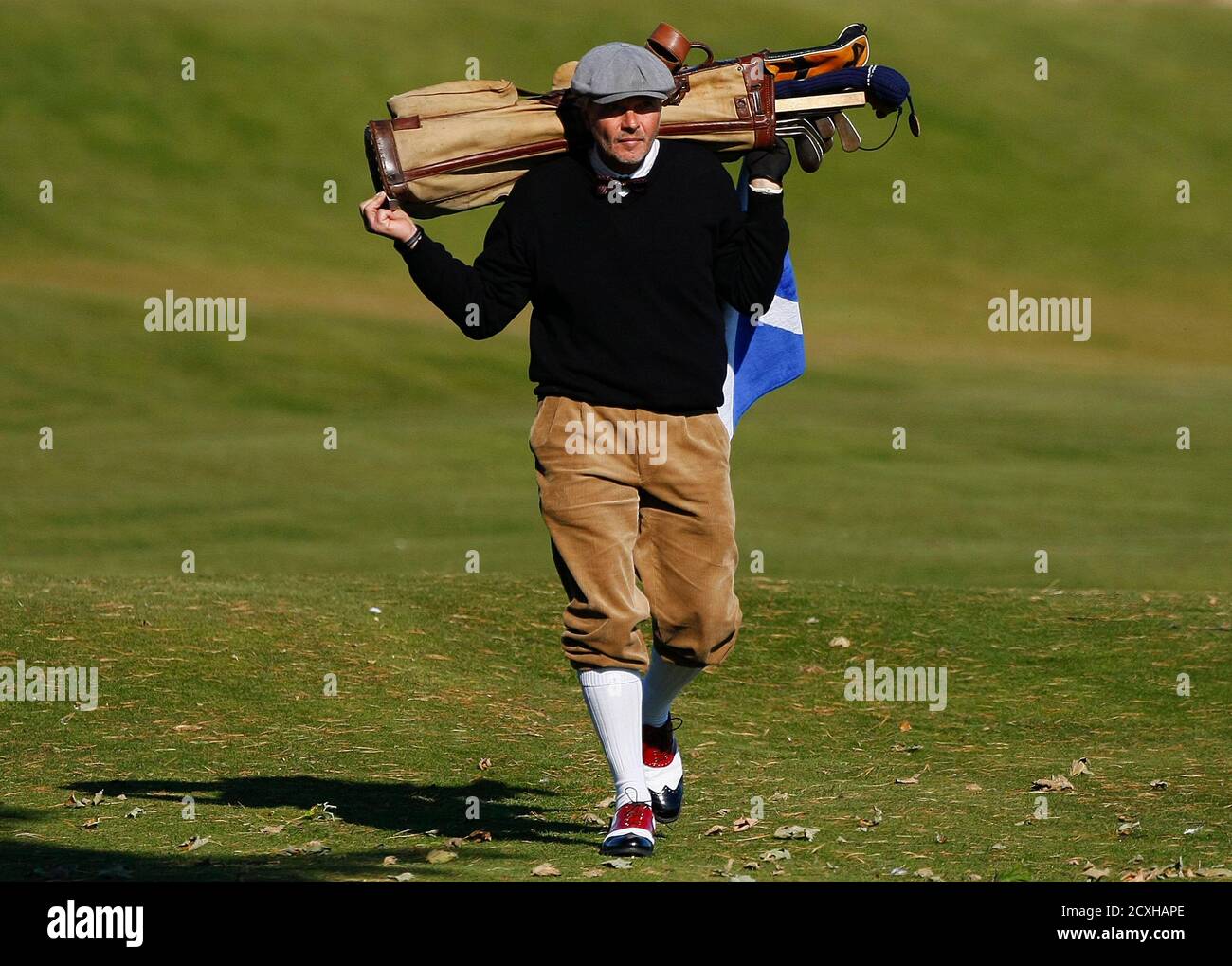A competitor taking part in the World Hickory Open golf championship walks  carrying his golf bag during the first round at Monifeith Links golf course  in Monifeith, east Scotland October 8, 2012.