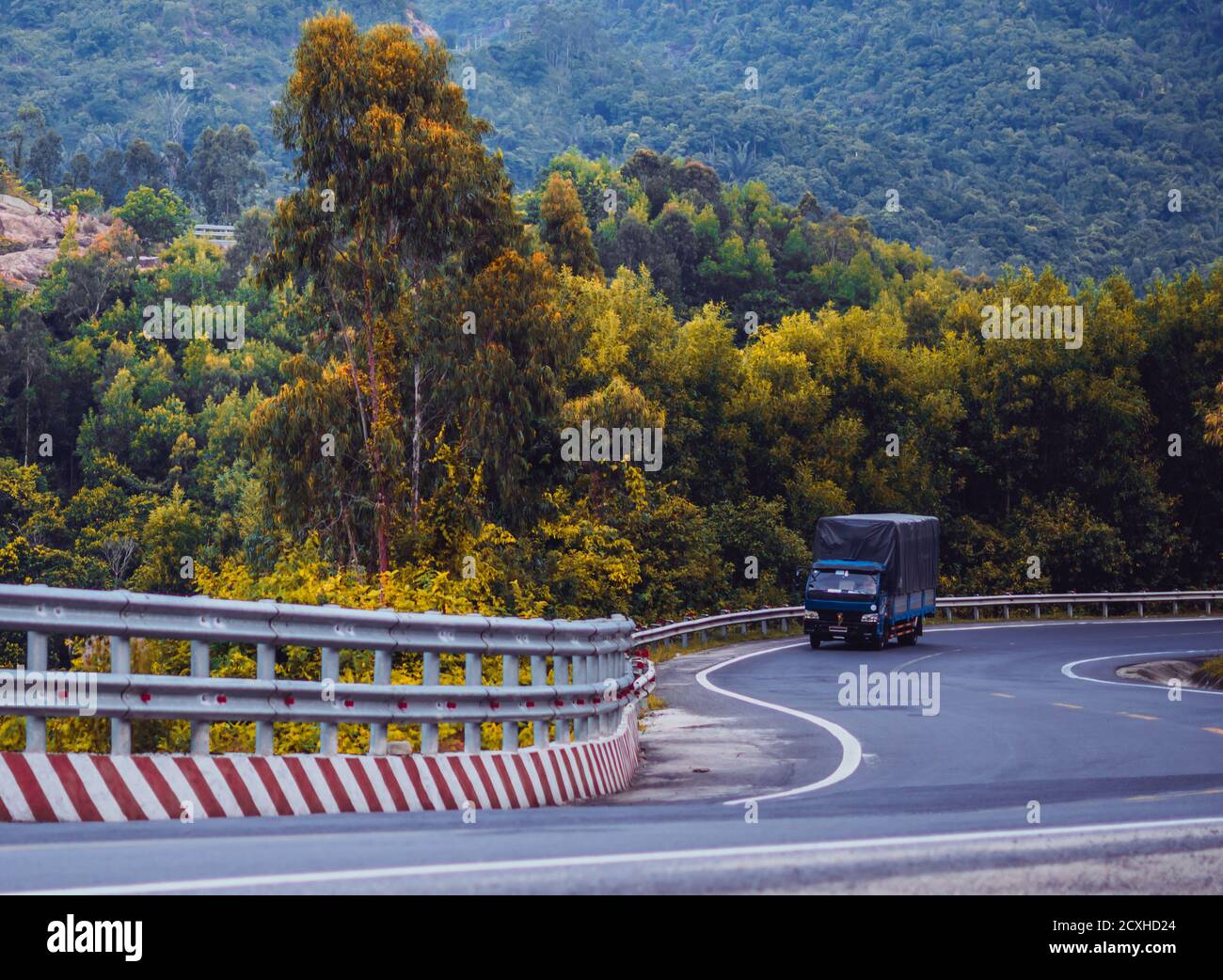 Time change future concept. Beauty panorama landscape Dry asphalt truck automobile winding road with marking lines in forested nebula mountain Stock Photo