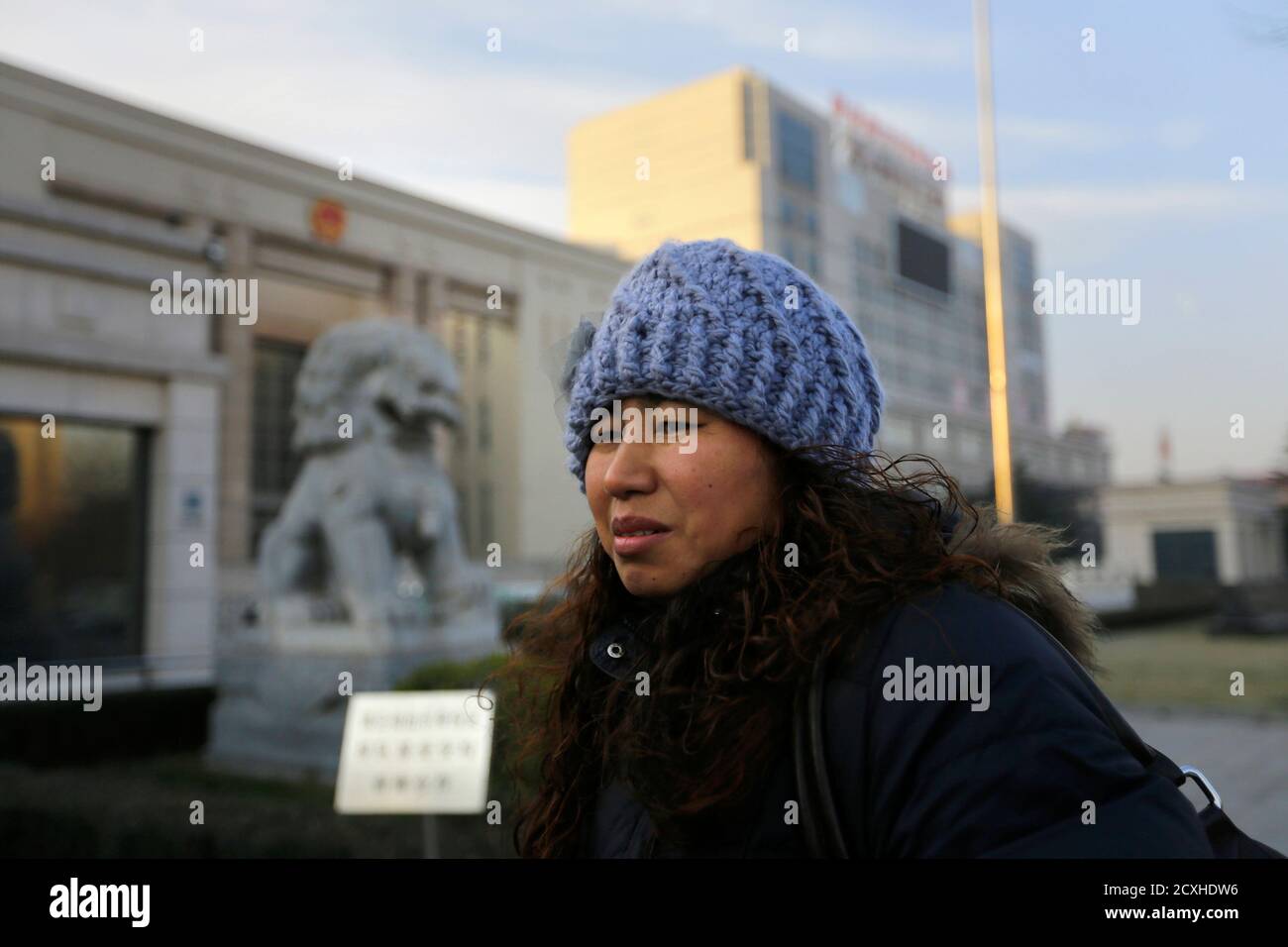 Liu Fei, 41-year-old warehouse worker, waits to enter a courthouse for a hearing in Fangshan, district of Beijing, December 6, 2013. Chinese warehouse worker Liu Fei was fined 330,000 yuan ($54,200), or 14 times her yearly wage, for having a second child and her failure to pay means the boy has no access to basic rights like schooling and healthcare. Liu's desperation prompted a fruitless attempt to sell her kidney and her eight-year-old boy's plea to sell his instead. Their dilemma has now triggered a rare legal battle against the police for denying the boy a 'hukou' - household registration  Stock Photo