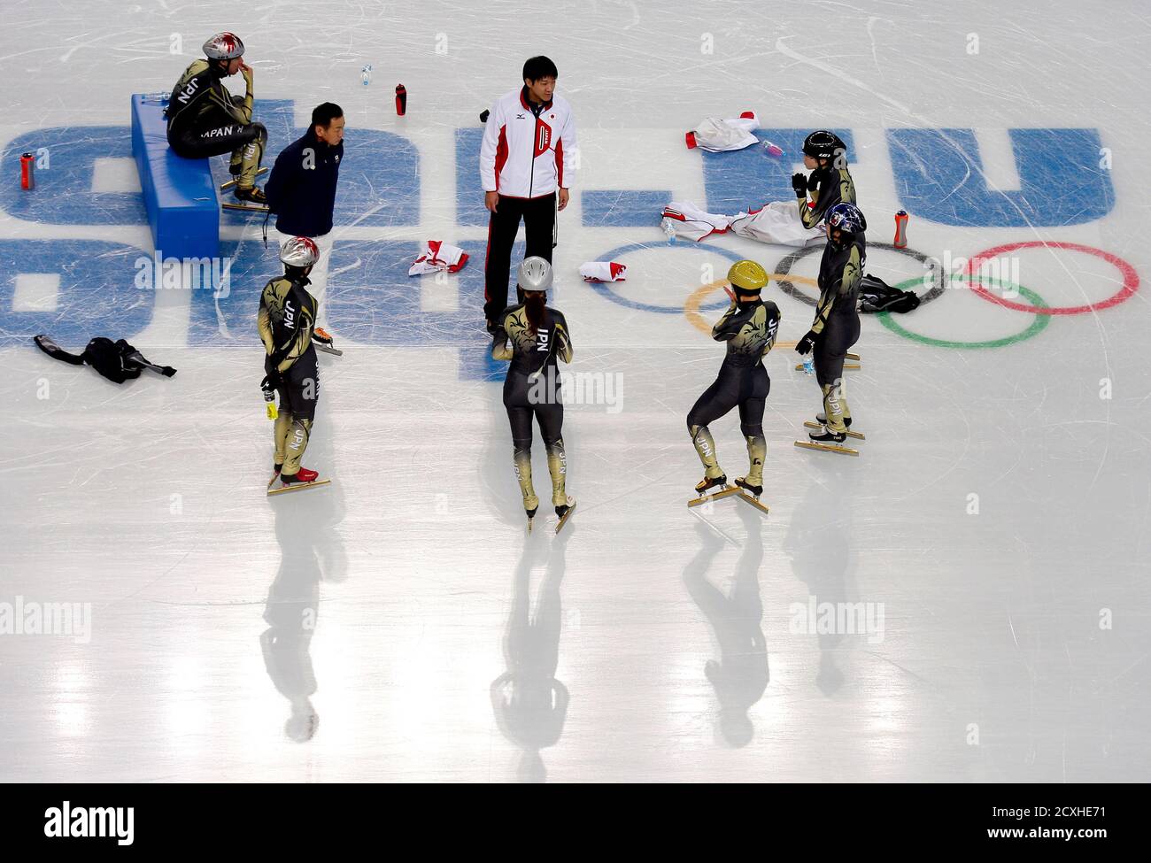 Skaters from Japan listen to a coach as they take a break during a short  track speed skating team training session in preparation for the 2014 Sochi  Winter Olympics at the Iceberg