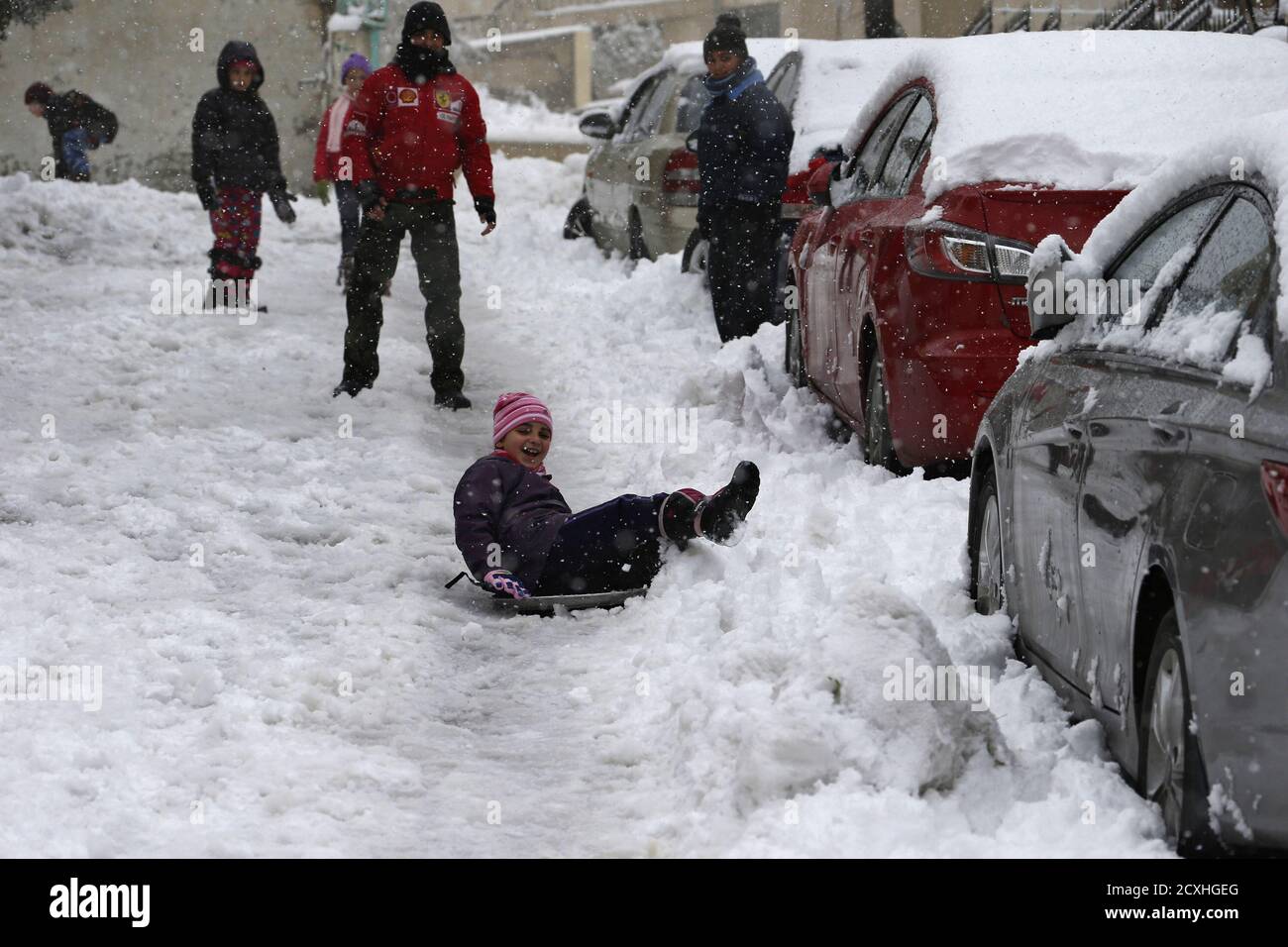 Children play with snow during a heavy snowstorm in Amman January 9, 2015.  A storm buffeted the Middle East with blizzards, rain and strong winds,  keeping people at home across much of