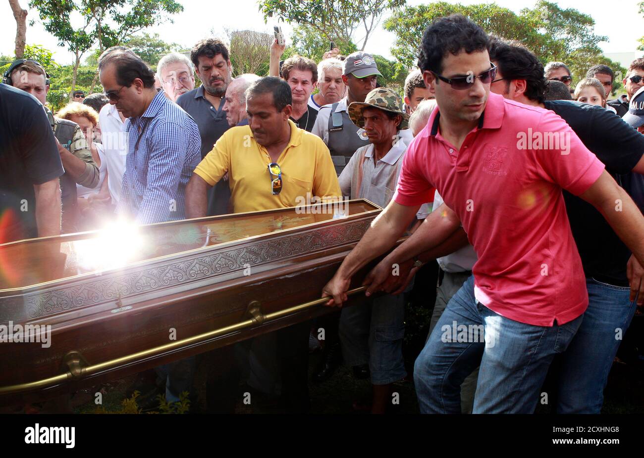 Gustavo Oliveira (R) carries the coffin of his father, Brazil's 1982 World Cup captain Socrates, during his funeral ceremony in Ribeirao Preto December 4, 2011. Socrates, the 'Golden Heel' renowned as one of the great playmakers of his generation, died in hospital on Sunday of septic shock at the age of 57, his doctors said in a statement. REUTERS/Paulo Whitaker (BRAZIL - Tags: SPORT SOCCER OBITUARY) Stock Photo