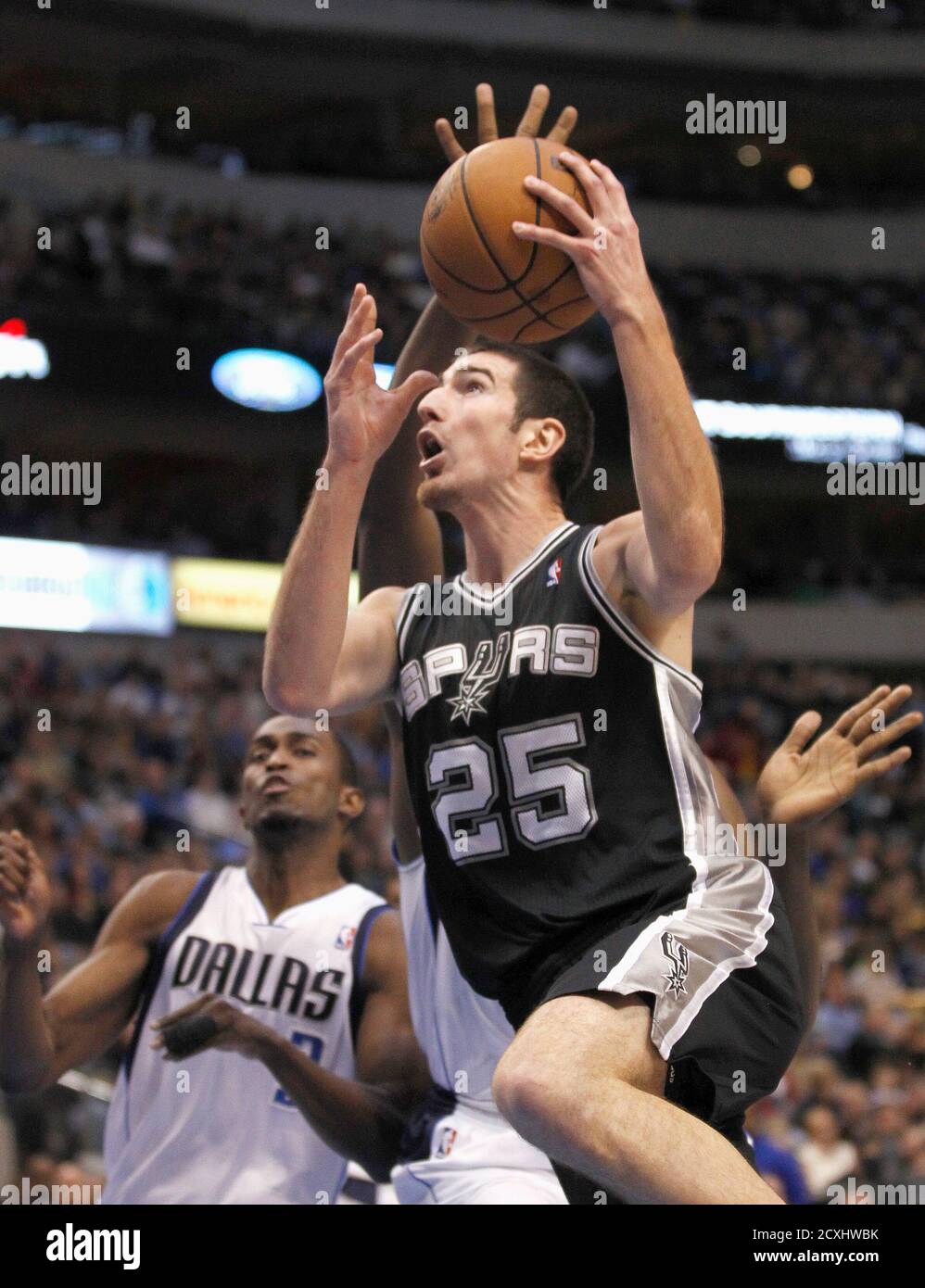 San Antonio Spurs Guard Nando De Colo Goes Up For The Shot As Dallas Mavericks Guard Rodrigue Beaubois L And Forward Elton Brand Are Near During The First Half Of Their Nba