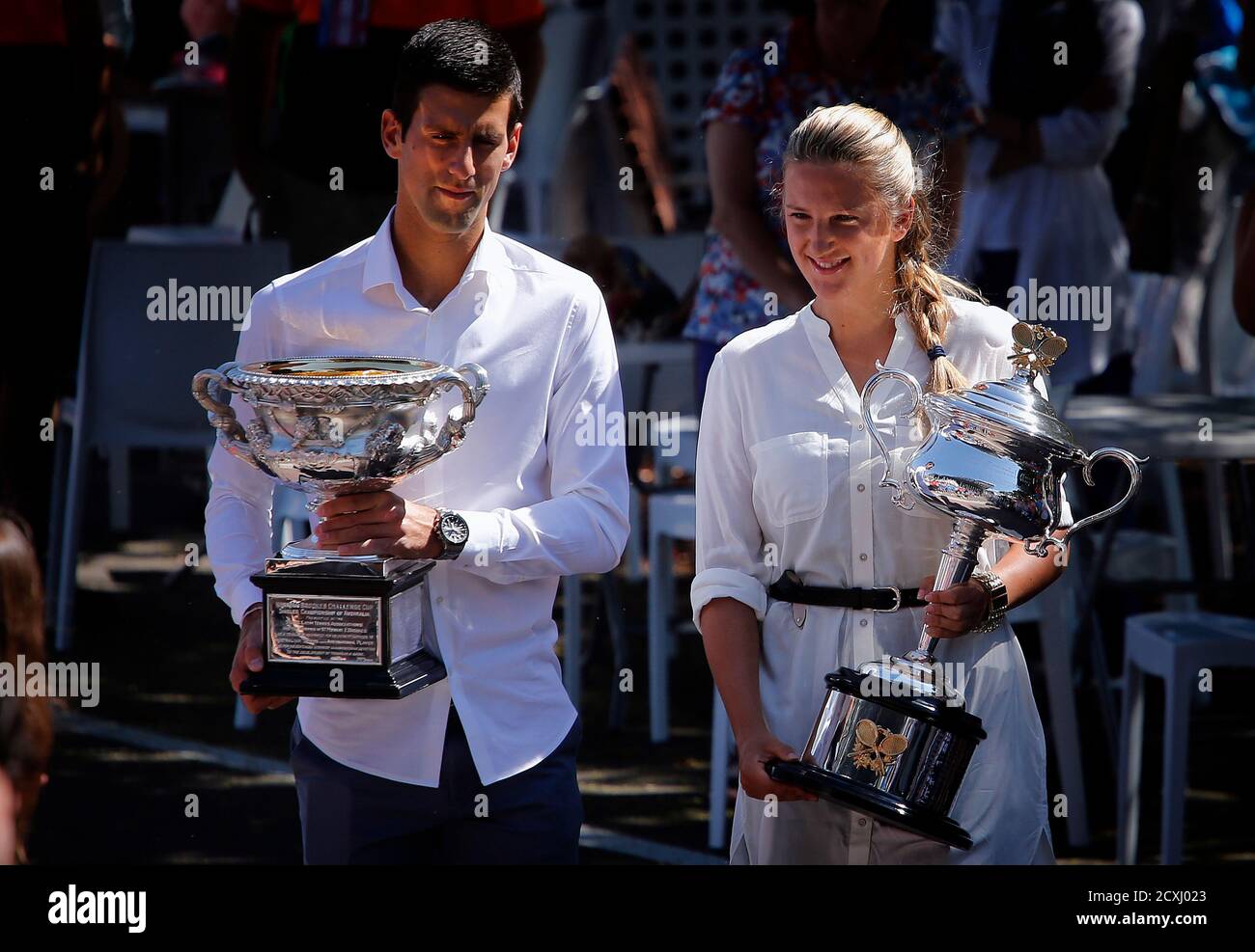 Current Australian Open tennis champions Serbia's Novak Djokovic (L) and Victoria Azarenka from Belarus walk with the championship trophies to the official draw ceremony Melbourne Park January 10, 2014. The Australian
