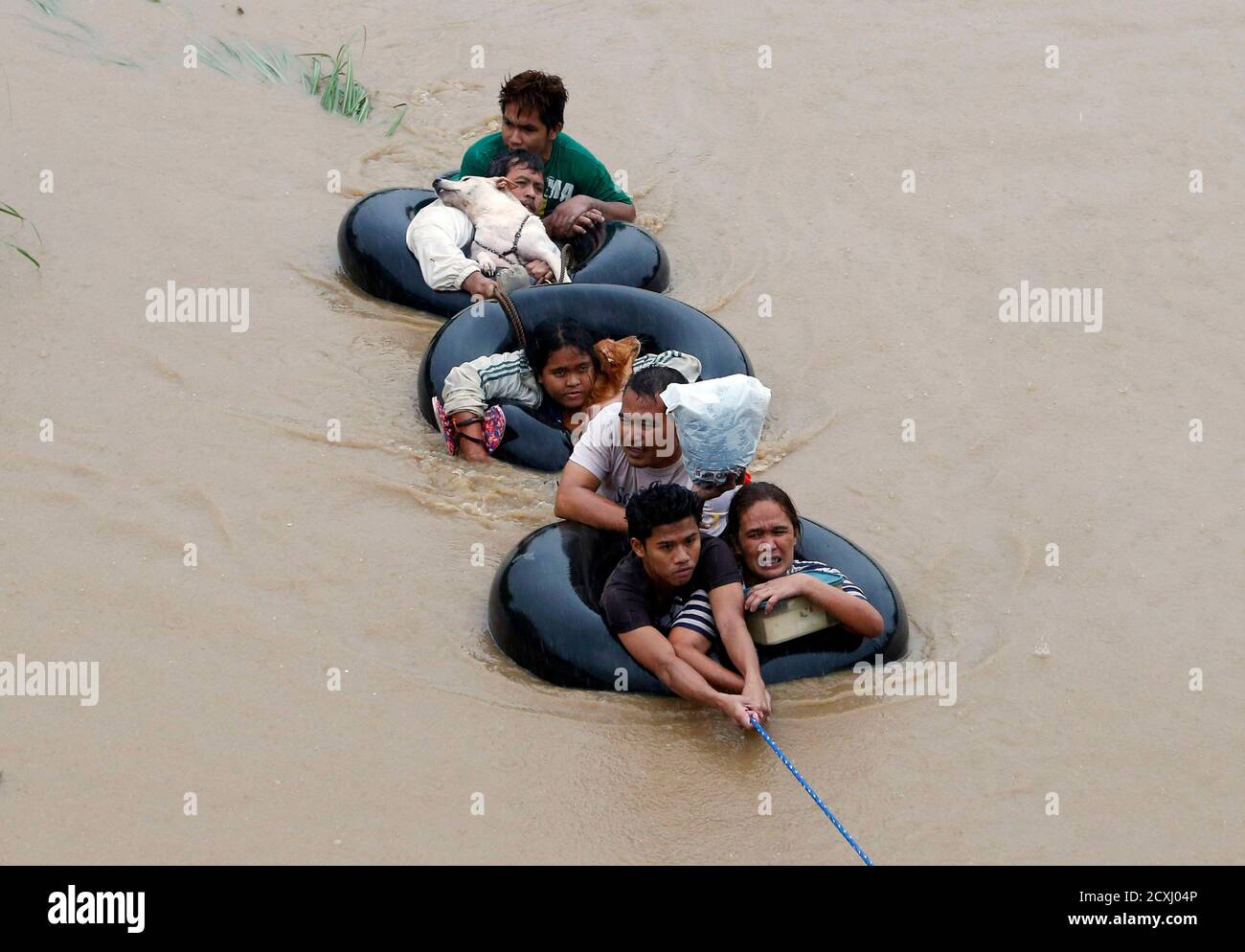 Flood victims are pulled on inflatable tire tubes as they are evacuated from heavy flooding brought by tropical depression 'Agaton', in Butuan, in the southern Philippine island of Mindanao January 20, 2014. Floods and landslides caused by tropical depression 'Agaton'  have killed 40 people and more than 500,000 people are displaced in Mindanao, the National Disaster Risk Reduction and Management Council reported on Sunday.   REUTERS/Erik De Castro (PHILIPPINES - Tags: DISASTER ENVIRONMENT TPX IMAGES OF THE DAY) Stock Photo