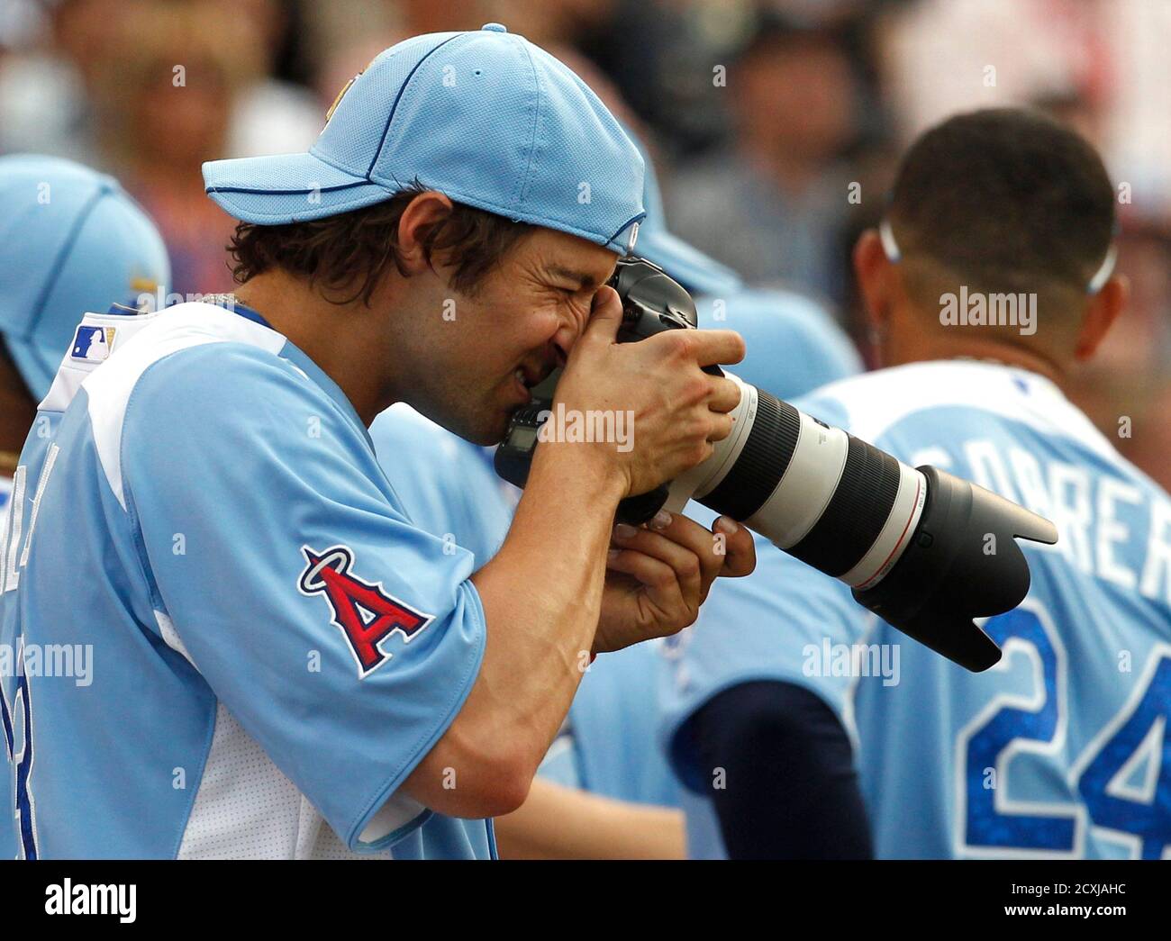 American League All-Star C.J. Wilson of the Los Angeles Angels tries out a  professional's camera during the Major League Baseball All-Star Game Home  Run Derby in Kansas City, Missouri, July 9, 2012.