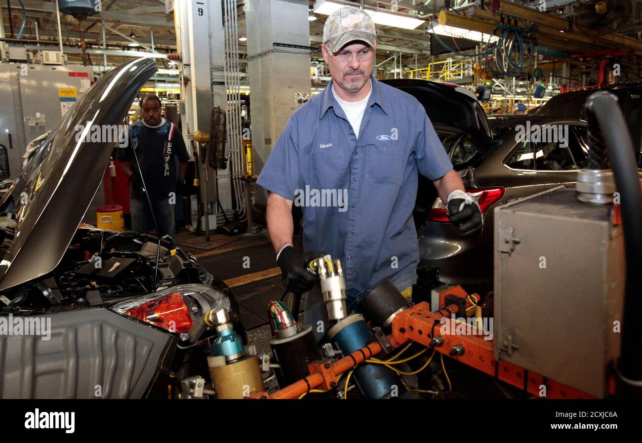 Ford Motor assembly employee Chris Howell works on the assembly line producing the 2013 Ford C-MAX Hybrid, C-MAX Energi plug-in Hybrids and the Focus gas-powered and Focus Electric vehicles at the Michigan Assembly Plant in Wayne, Michigan November 8, 2012.  REUTERS/Rebecca Cook  (UNITED STATES - Tags: TRANSPORT BUSINESS) Stock Photo