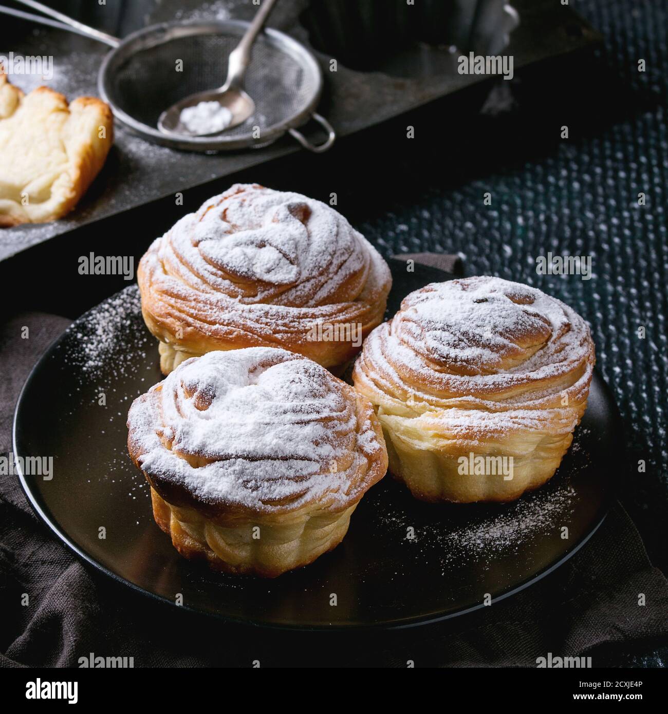 Modern pastries cruffins, whole and slice, like croissant and muffin with sugar powder, served