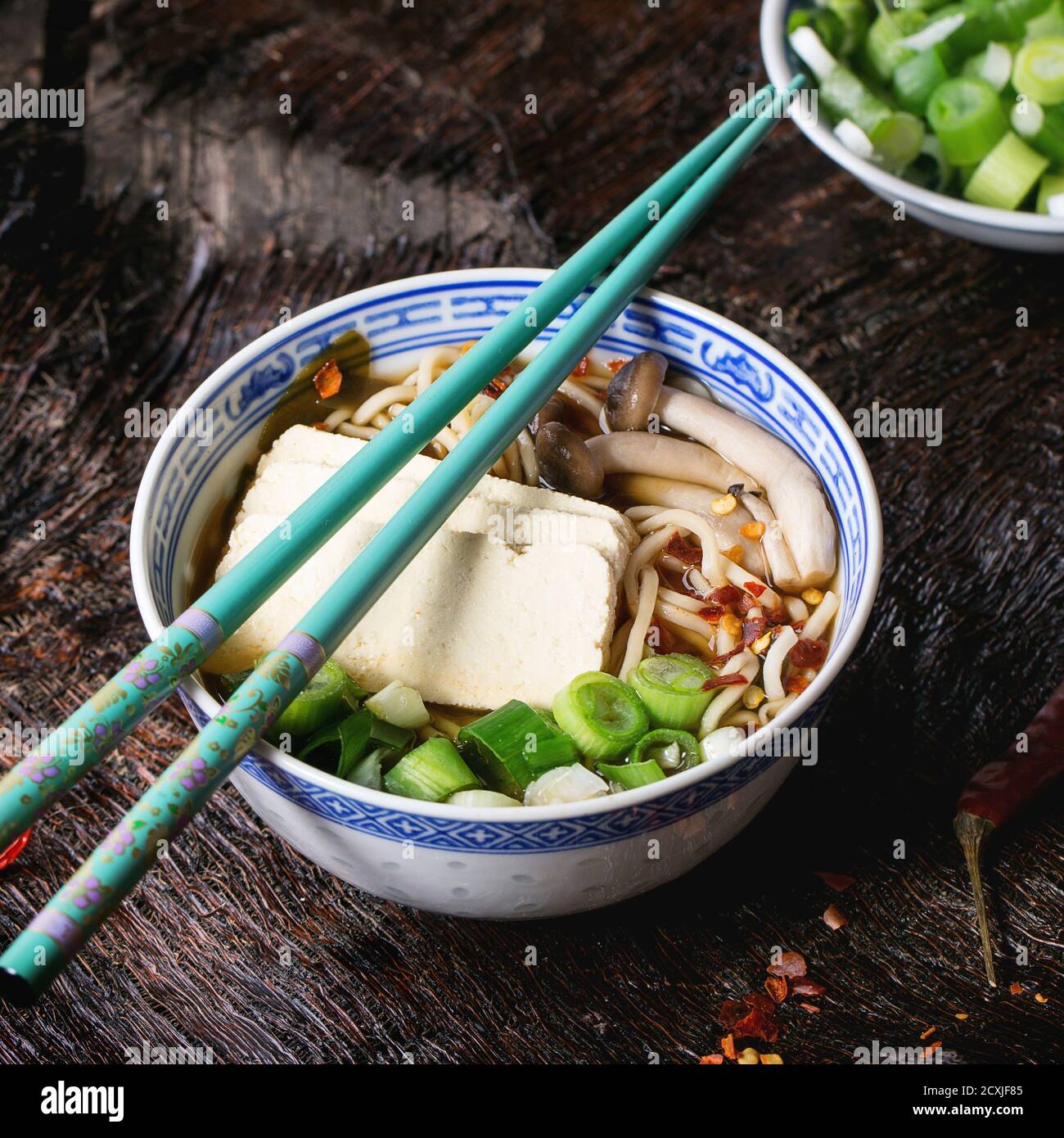 Chinese Porcelain Bowl Of Asian Ramen Soup With Feta Cheese Noodles Spring Onion And Mushrooms Served With Turquoise Chopsticks Over Old Wooden Tab Stock Photo Alamy