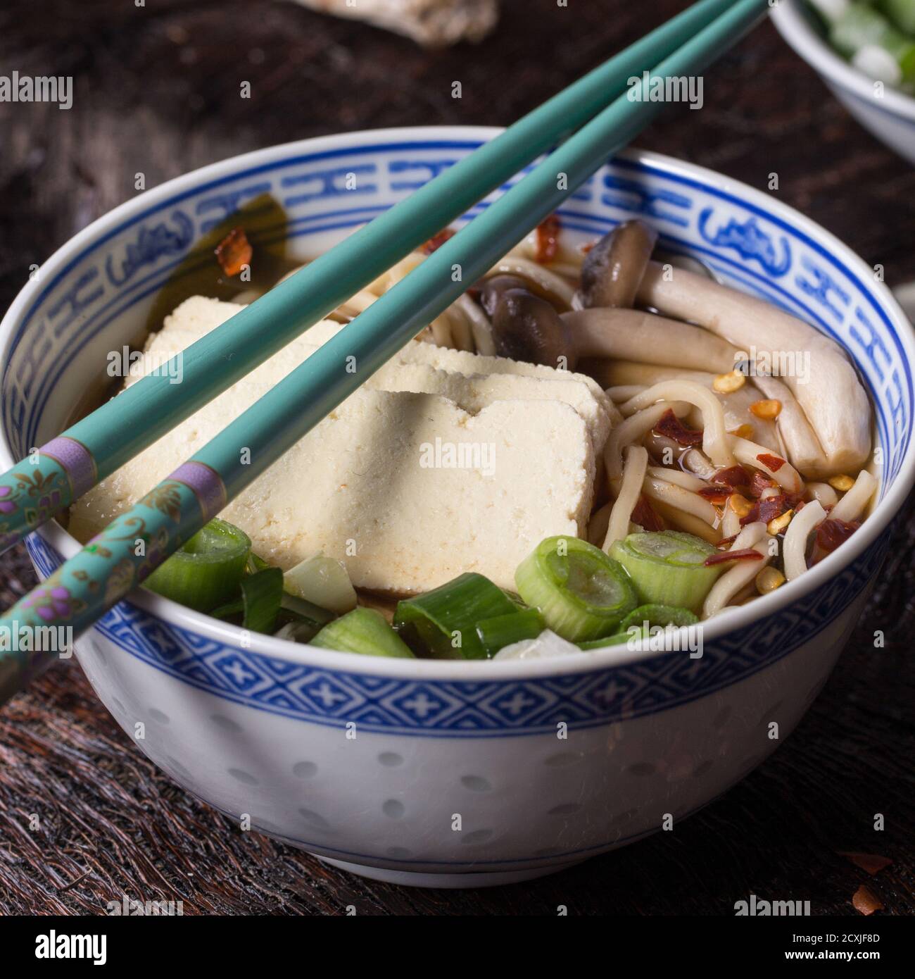 Chinese Porcelain Bowl Of Asian Ramen Soup With Feta Cheese Noodles Spring Onion And Mushrooms Served With Turquoise Chopsticks Over Old Wooden Tab Stock Photo Alamy