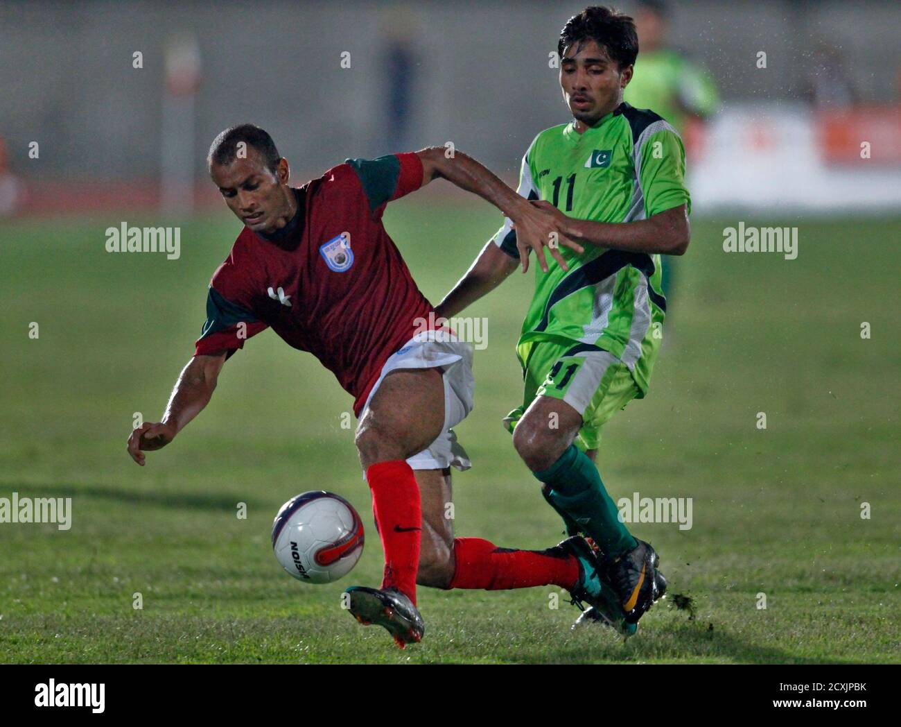 Bangladesh Rezaul (L) fights for the ball with Pakistan's Husnain Abbas during their 2014 World Cup qualifying soccer match at Punjab stadium in Lahore July 3, 2011. REUTERS/Mohsin Raza   (PAKISTAN - Tags: SPORT SOCCER) Stock Photo