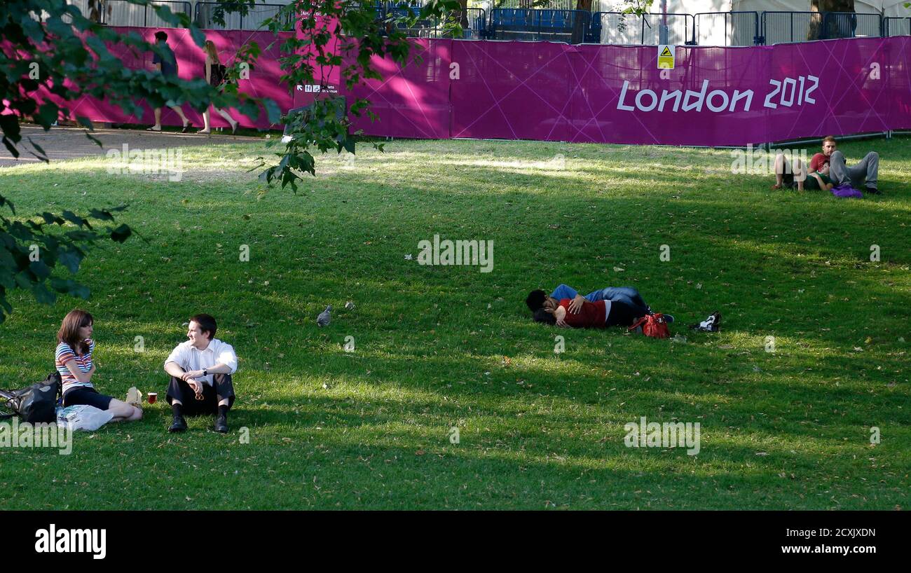 Couples enjoy the afternoon sun as they sit in St James's Park in London, England July 24, 2012. REUTERS/Phil Noble (BRITAIN - Tags: SPORT ENVIRONMENT SOCIETY OLYMPICS) Stock Photo