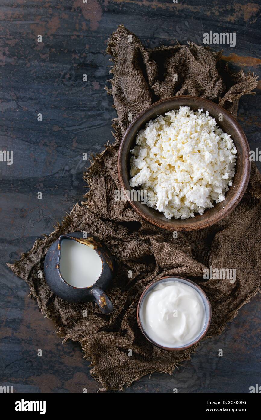 Brown ceramic bowl of homemade cottage cheese with yogurt and jug of ...