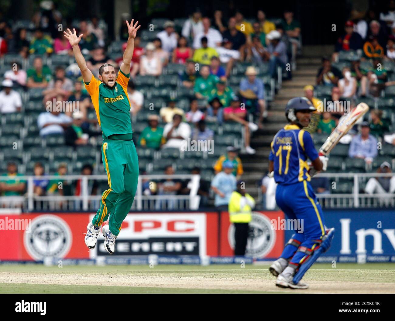 South Africa's Wayne Parnell celebrates the dismissal of Sri Lanka's Dinesh Chandimal (R) who was caught out by AB de Villiers during their fifth one-day international cricket match in Johannesburg January 22, 2012. REUTERS/Siphiwe Sibeko (SOUTH AFRICA - Tags: SPORT CRICKET) Stock Photo