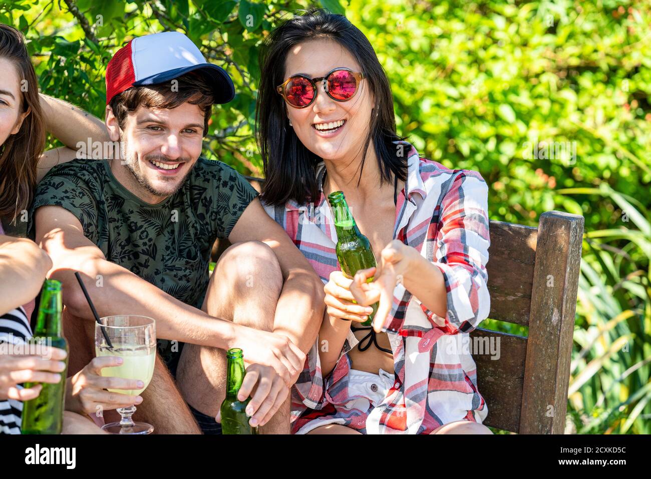 Young friends enjoying drinks at poolside Stock Photo