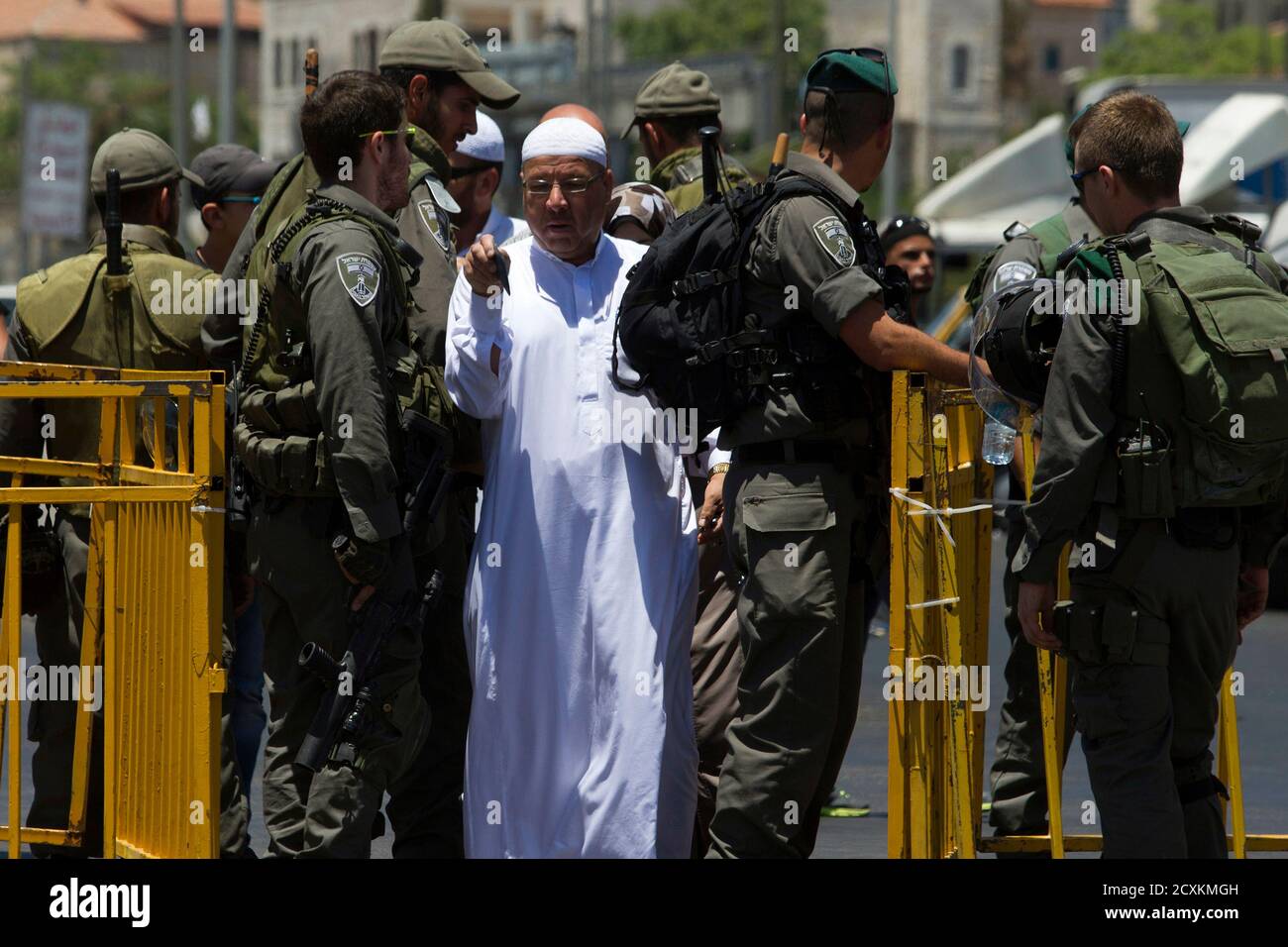A man walks past a checkpoint manned by Israeli police after showing his identity card, on the last Friday of the holy month of Ramadan close to the Damascus Gate of the Old City in Jerusalem July 25, 2014. REUTERS/Siegfried Modola (JERUSALEM - Tags: RELIGION) Stock Photo