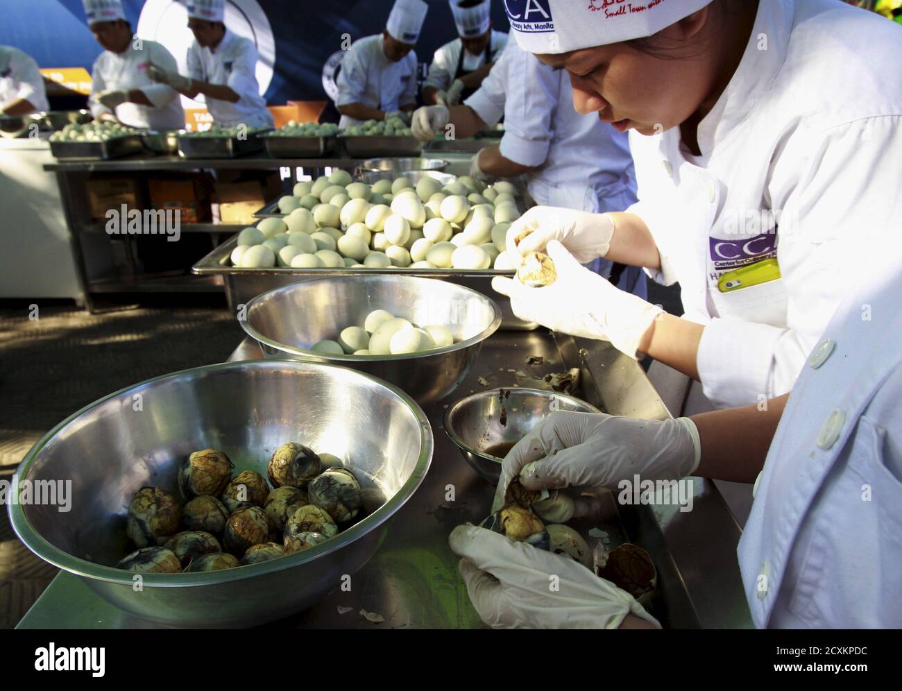 Students from the Center for Culinary Art Manila crack open hundreds of Balut, a local delicacy of boiled duck embryo, during an attempt to make a Guinness World Record in the Pateros municipality, metro Manila April 10, 2015. Participants try to make a Guinness World Record for Largest Edible Serving of Balut attaining a record of 117.5 kilograms of Balut in which the event aims to promote the local delicacy rather than a dare-food for foreign tourist, organizer said. REUTERS/Romeo Ranoco Stock Photo