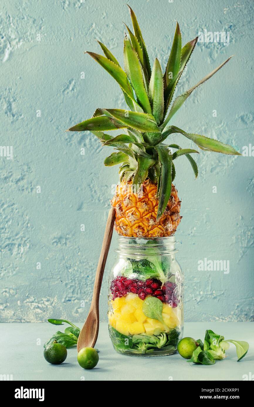 Salads in mason jar. Fruit salad with mango, pomegranate, greens ...