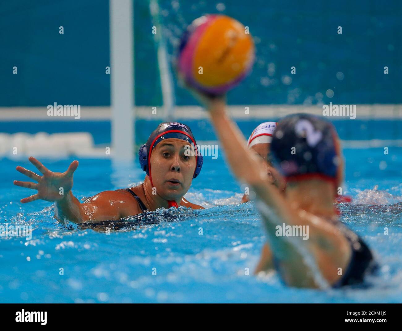 Courtney Mathewson (L) of the U.S. looks to receive a pass from her  teammate Heather Petri during their women's preliminary round Group A water  polo match against Spain at the London 2012