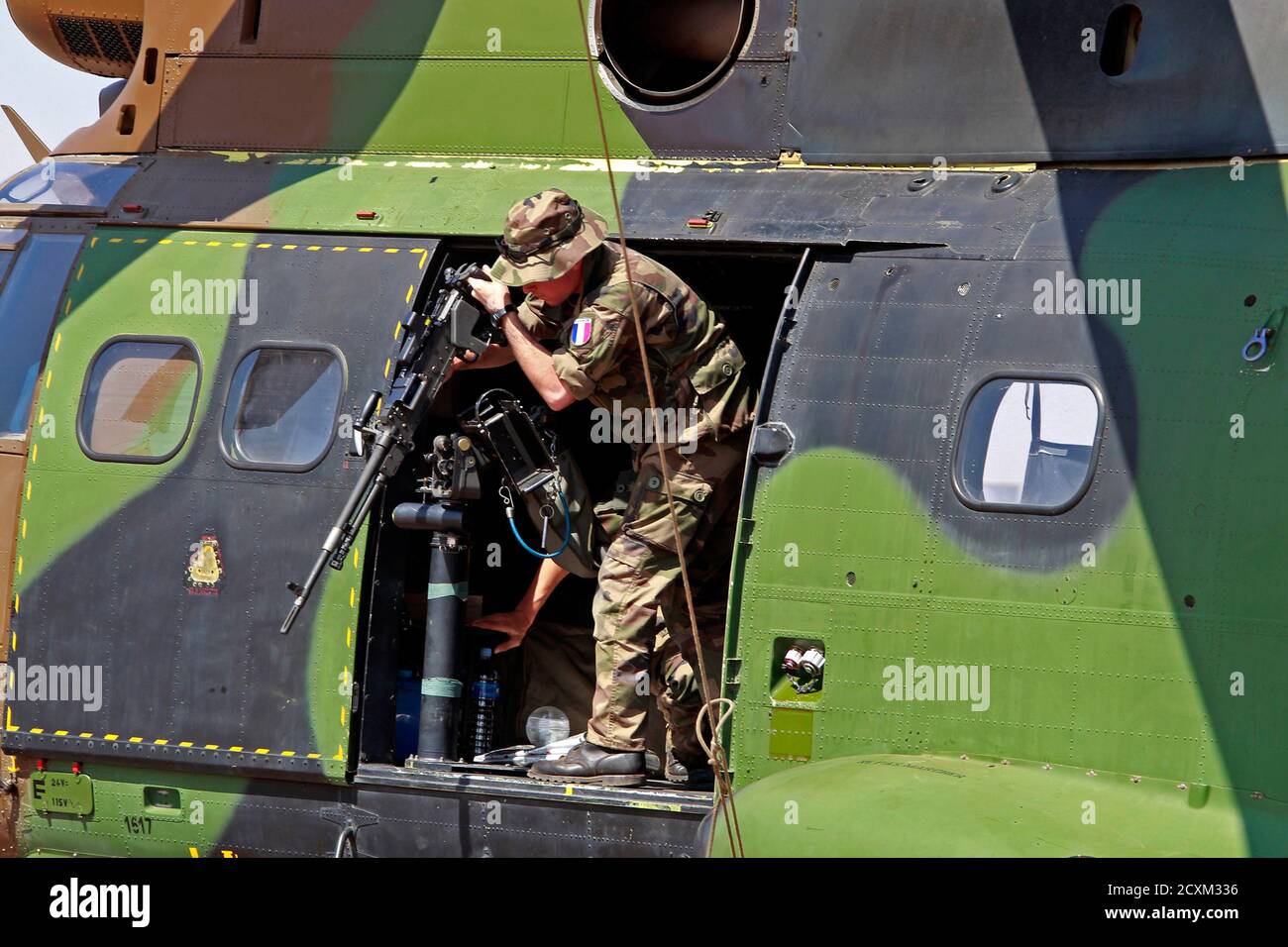 A French soldier removes a machine gun from a Puma helicopter at the Mali  air force base near Bamako January 19, 2013. Islamist rebels in Mali  abandoned the central town of Diabaly