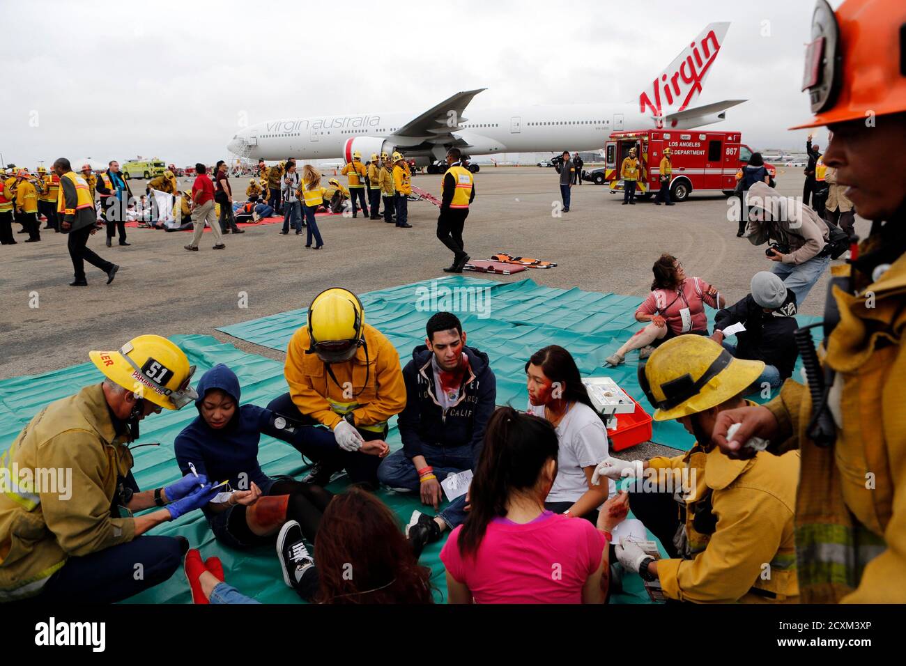 Actors portraying flight crash victims are treated by emergency personnel in a triage unit during the full-scale, LAX Air Exercise aircraft disaster simulation training drill at Los Angeles International Airport (LAX), in Los Angeles, California April 24, 2013. The LAX AirEx is a two-hour long simulated aircraft disaster with over 100 volunteers in moulage, role-playing as accident victims and is designed to test LAX's Emergency Response Plan, as required by the Federal Aviation Administration (FAA) at least once every three years to evaluate the operational capability and readiness of LAX's e Stock Photo