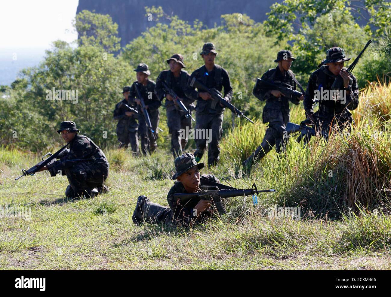 cadets-of-the-philippine-military-academy-pma-position-for-assault-during-a-joint-field-training-exercise-at-the-marines-headquarters-in-ternate-cavite-city-south-of-manila-may-29-2013-future-military-leaders-in-the-philippines-undergo-annual-drills-at-a-marine-base-to-train-them-on-coastal-defense-and-amphibious-operations-as-philippine-shifts-security-policy-from-fighting-rebels-to-defending-territories-in-disputed-waters-in-south-china-sea-reutersromeo-ranoco-philippines-tags-politics-military-2CXM466.jpg