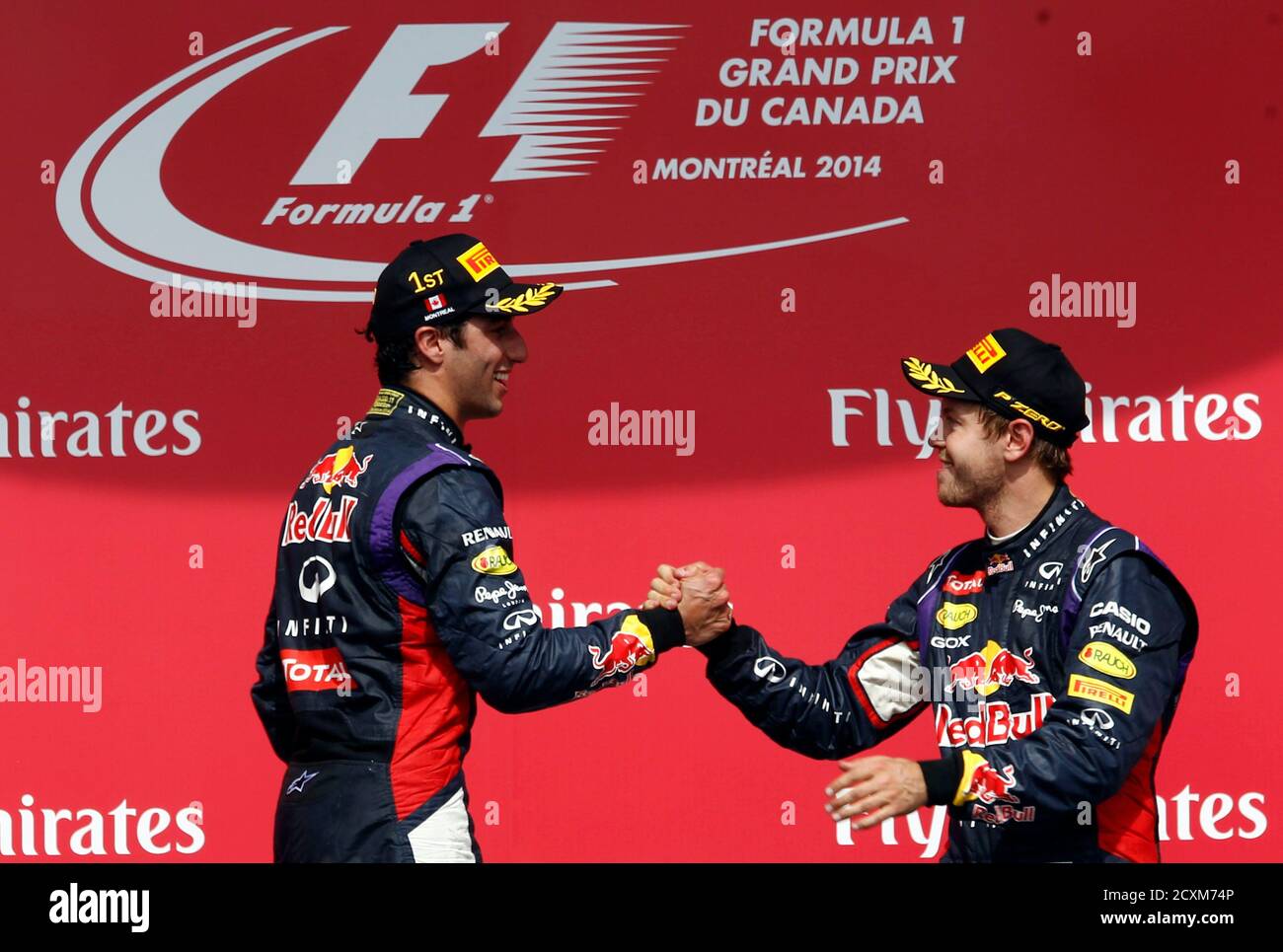 Red Bull Formula One driver Daniel Ricciardo of Australia (L) is congratulated by teammate and thrid place finisher Sebastian Vettel of Germany (R) after winning the Canadian F1 Grand Prix at the Circuit Gilles Villeneuve in Montreal June 8, 2014.  REUTERS/Chris Wattie (CANADA  - Tags: SPORT MOTORSPORT F1) Stock Photo
