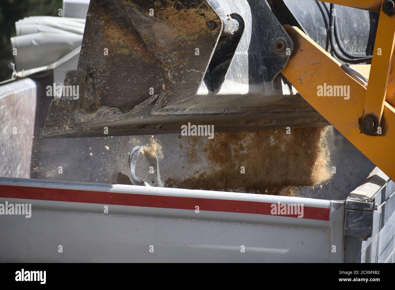 Digger Bucket Emptying Dirt into Dump Truck Stock Photo Alamy