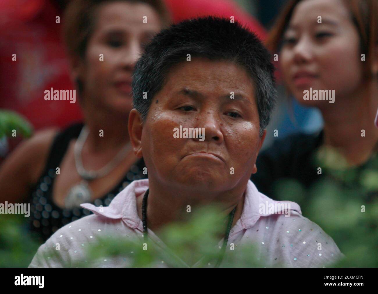 A supporter of the Democrat Party reacts at her party's headquarters after voting in general elections ended in Bangkok July 3, 2011. Thailand's opposition swept to power in a surprise election landslide on Sunday, led by the sister of former Thai prime minister Thaksin Shinawatra in a victory for the rural and urban poor red-shirt protesters who clashed with the army last year. REUTERS/Chaiwat Subprasom   (THAILAND POLITICS - Tags: POLITICS ELECTIONS) Stock Photo
