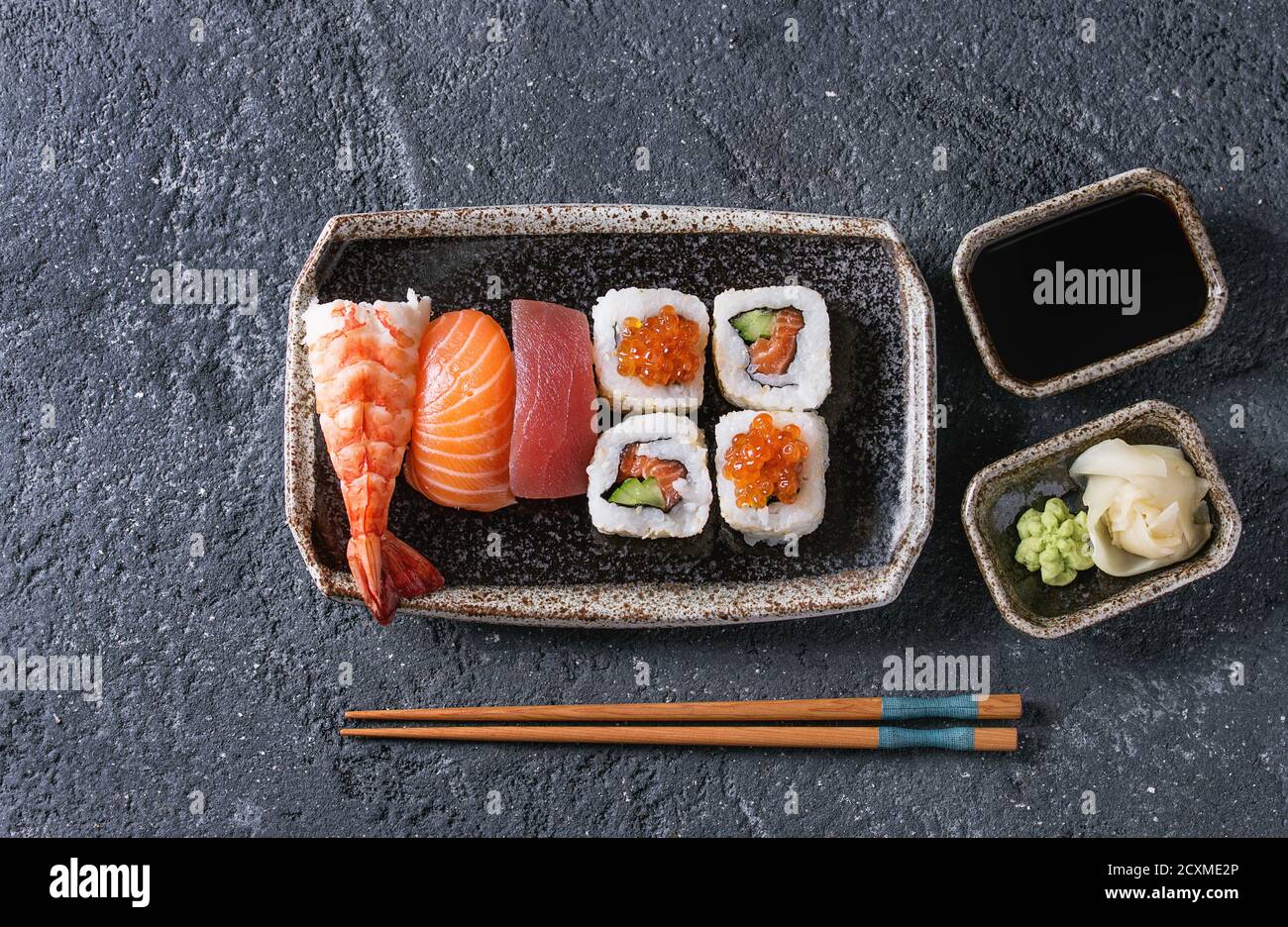 Sushi Set nigiri and sushi rolls in dark ceramic plate with soy sauce ...