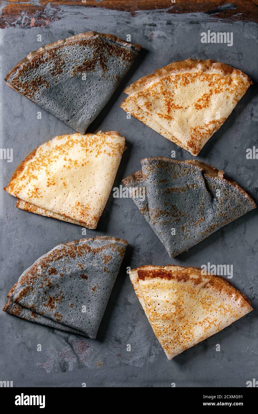 Variety of black and white empty crepe pancakes. Over gray metal background. Top view Stock Photo