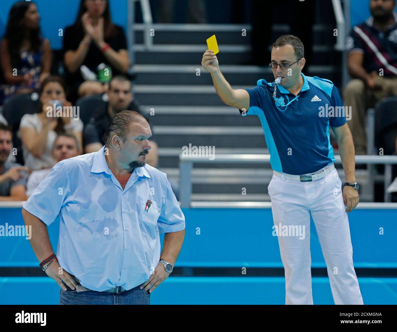 Hungary head coach Andras Meresz (L) is shown a yellow card by the referee  as his team met Australia during their Women's Bronze Medal water polo  match during the London 2012 Olympic