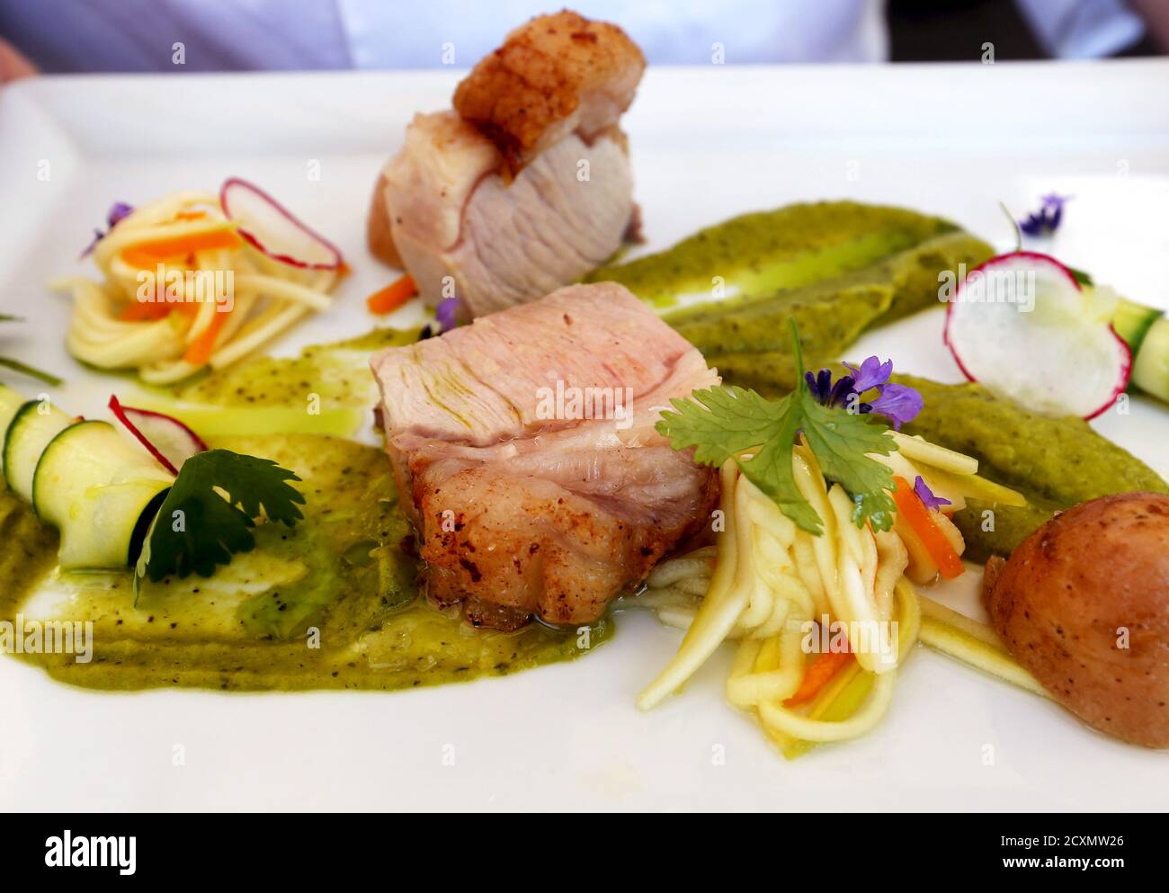A chef at restaurant Bock Bisztro holds up a plate of roast Hungarian "mangalica" pork with seasonal greens in Budapest, Hungary, June 10, 2015. Mangalicas, which were all but extinct 25 years ago, now feature prominently in some of the best restaurants in the world for their meat, which gets its exceptional taste from the fat stored inside the muscle tissue. Picture taken June 10, 2015. REUTERS/Laszlo Balogh Stock Photo
